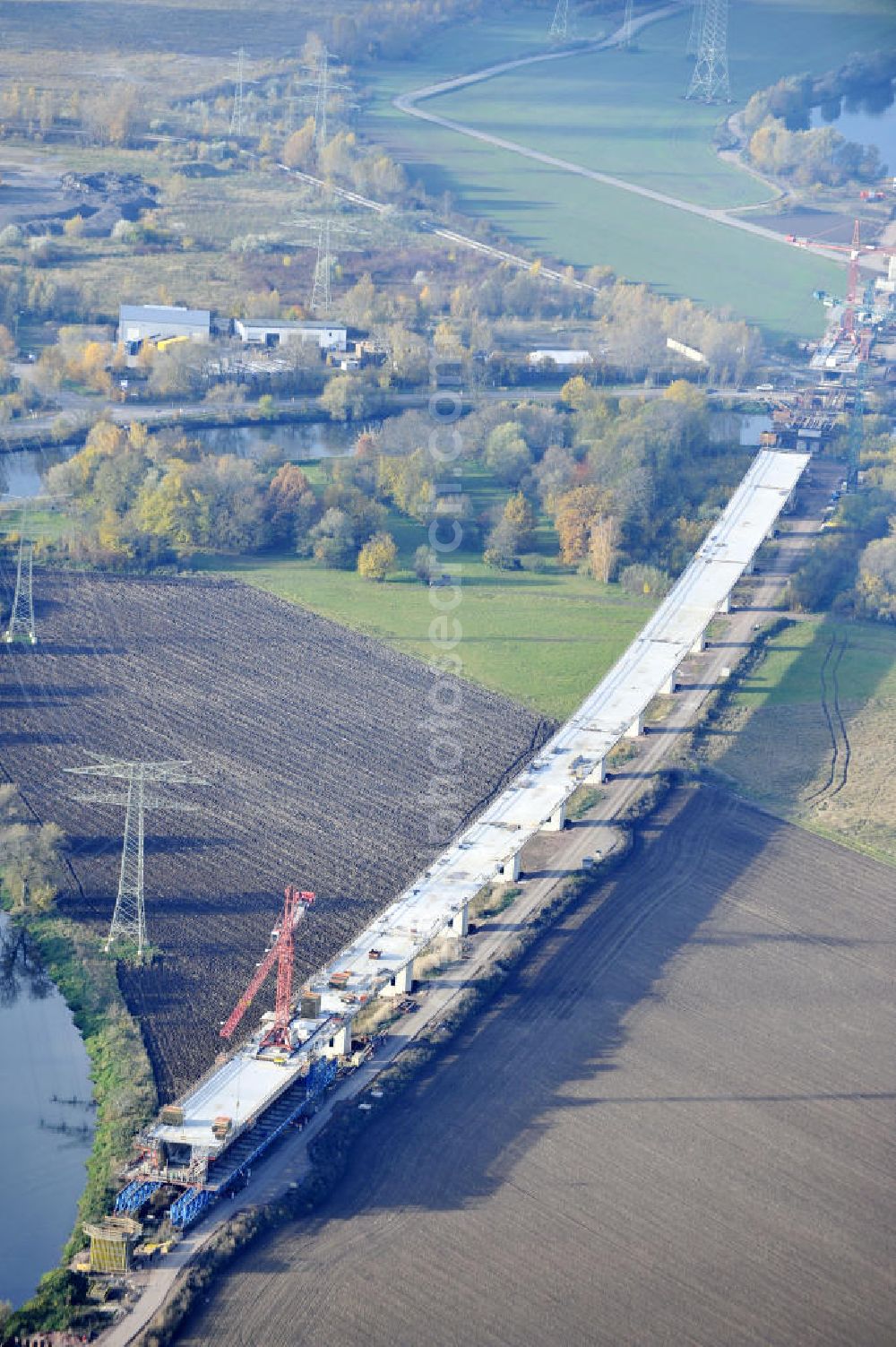 Aerial photograph Rattmannsdorf - Blick auf die Vorschub- Bauarbeiten an der Saale-Elster-Talbrücke zwischen Ammendorf und Schkopau. Das Beton- Viadukt mit insgesamt 8, 5 Kilometern Länge wird teilweise mit großen Baugerüsten in so genannter Vor-Kopf-Bauweise errichtet. Die ICE - Neubaustrecke im Projekt VDE 8 Nürnberg-Berlin der Deutschen Bahn und der DEGES soll 2015 in Betrieb gehen und wird das bisher längste Brückenbauwerk Deutschlands sein. Bauausführende Firmen sind die Hochtief Construction AG, Adam Hörnig, Gerdum und Breuer; Franki Grundbau; Doka Schalungstechniker; BBV Vorspanntechnik; Röro Traggerüstsysteme; Oevermann Hoch- und Tiefbau, Teupe & Söhne Gerüstbau GmbH, Alpine Bau, Kann Baustoffe und Arcelormittal. Die Bauüberwachung erfolgt durch das Ingenieurbüro Schüßler Plan. View of the construction of the Saale-Elster Viaduct between Ammandorf and Schkopau in Saxony Anhalt.