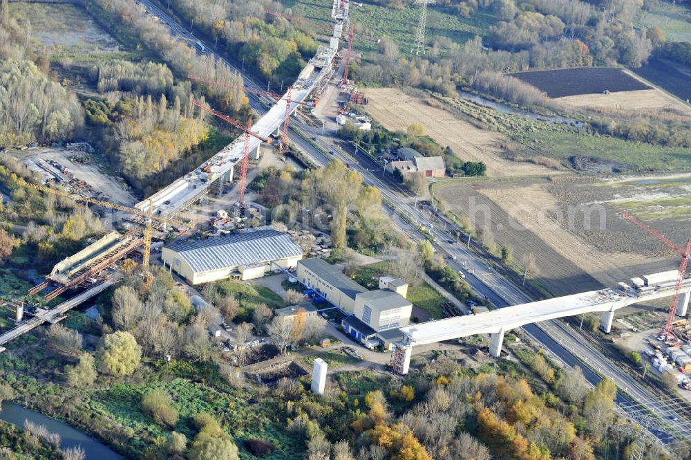 Aerial photograph Rattmannsdorf - Blick auf die Vorschub- Bauarbeiten an der Saale-Elster-Talbrücke zwischen Ammendorf und Schkopau. Das Beton- Viadukt mit insgesamt 8, 5 Kilometern Länge wird teilweise mit großen Baugerüsten in so genannter Vor-Kopf-Bauweise errichtet. Die ICE - Neubaustrecke im Projekt VDE 8 Nürnberg-Berlin der Deutschen Bahn und der DEGES soll 2015 in Betrieb gehen und wird das bisher längste Brückenbauwerk Deutschlands sein. Bauausführende Firmen sind die Hochtief Construction AG, Adam Hörnig, Gerdum und Breuer; Franki Grundbau; Doka Schalungstechniker; BBV Vorspanntechnik; Röro Traggerüstsysteme; Oevermann Hoch- und Tiefbau, Teupe & Söhne Gerüstbau GmbH, Alpine Bau, Kann Baustoffe und Arcelormittal. Die Bauüberwachung erfolgt durch das Ingenieurbüro Schüßler Plan. View of the construction of the Saale-Elster Viaduct between Ammandorf and Schkopau in Saxony Anhalt.