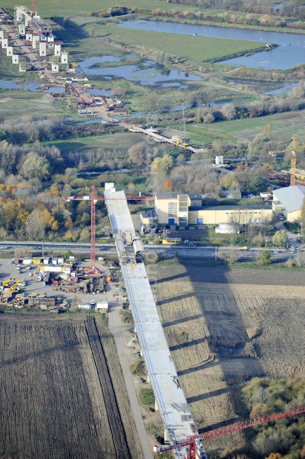 Rattmannsdorf from the bird's eye view: Blick auf die Vorschub- Bauarbeiten an der Saale-Elster-Talbrücke zwischen Ammendorf und Schkopau. Das Beton- Viadukt mit insgesamt 8, 5 Kilometern Länge wird teilweise mit großen Baugerüsten in so genannter Vor-Kopf-Bauweise errichtet. Die ICE - Neubaustrecke im Projekt VDE 8 Nürnberg-Berlin der Deutschen Bahn und der DEGES soll 2015 in Betrieb gehen und wird das bisher längste Brückenbauwerk Deutschlands sein. Bauausführende Firmen sind die Hochtief Construction AG, Adam Hörnig, Gerdum und Breuer; Franki Grundbau; Doka Schalungstechniker; BBV Vorspanntechnik; Röro Traggerüstsysteme; Oevermann Hoch- und Tiefbau, Teupe & Söhne Gerüstbau GmbH, Alpine Bau, Kann Baustoffe und Arcelormittal. Die Bauüberwachung erfolgt durch das Ingenieurbüro Schüßler Plan. View of the construction of the Saale-Elster Viaduct between Ammandorf and Schkopau in Saxony Anhalt.