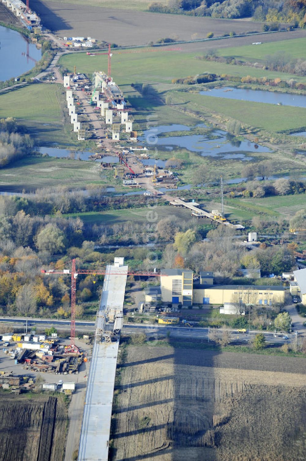 Rattmannsdorf from above - Blick auf die Vorschub- Bauarbeiten an der Saale-Elster-Talbrücke zwischen Ammendorf und Schkopau. Das Beton- Viadukt mit insgesamt 8, 5 Kilometern Länge wird teilweise mit großen Baugerüsten in so genannter Vor-Kopf-Bauweise errichtet. Die ICE - Neubaustrecke im Projekt VDE 8 Nürnberg-Berlin der Deutschen Bahn und der DEGES soll 2015 in Betrieb gehen und wird das bisher längste Brückenbauwerk Deutschlands sein. Bauausführende Firmen sind die Hochtief Construction AG, Adam Hörnig, Gerdum und Breuer; Franki Grundbau; Doka Schalungstechniker; BBV Vorspanntechnik; Röro Traggerüstsysteme; Oevermann Hoch- und Tiefbau, Teupe & Söhne Gerüstbau GmbH, Alpine Bau, Kann Baustoffe und Arcelormittal. Die Bauüberwachung erfolgt durch das Ingenieurbüro Schüßler Plan. View of the construction of the Saale-Elster Viaduct between Ammandorf and Schkopau in Saxony Anhalt.