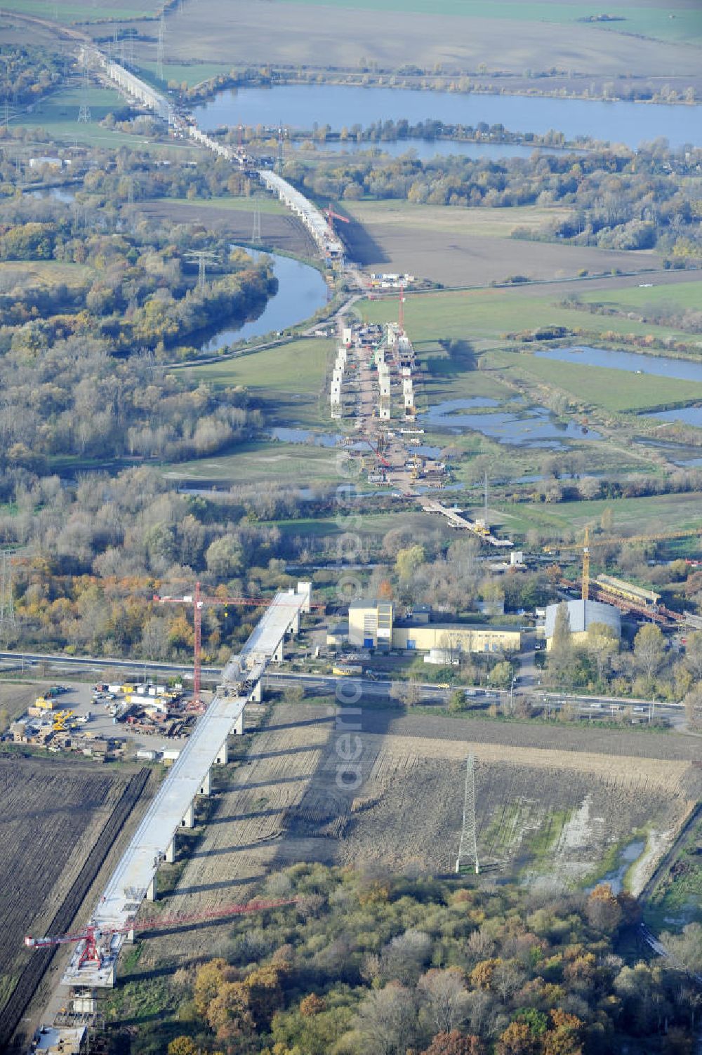 Rattmannsdorf from the bird's eye view: Blick auf die Vorschub- Bauarbeiten an der Saale-Elster-Talbrücke zwischen Ammendorf und Schkopau. Das Beton- Viadukt mit insgesamt 8, 5 Kilometern Länge wird teilweise mit großen Baugerüsten in so genannter Vor-Kopf-Bauweise errichtet. Die ICE - Neubaustrecke im Projekt VDE 8 Nürnberg-Berlin der Deutschen Bahn und der DEGES soll 2015 in Betrieb gehen und wird das bisher längste Brückenbauwerk Deutschlands sein. Bauausführende Firmen sind die Hochtief Construction AG, Adam Hörnig, Gerdum und Breuer; Franki Grundbau; Doka Schalungstechniker; BBV Vorspanntechnik; Röro Traggerüstsysteme; Oevermann Hoch- und Tiefbau, Teupe & Söhne Gerüstbau GmbH, Alpine Bau, Kann Baustoffe und Arcelormittal. Die Bauüberwachung erfolgt durch das Ingenieurbüro Schüßler Plan. View of the construction of the Saale-Elster Viaduct between Ammandorf and Schkopau in Saxony Anhalt.