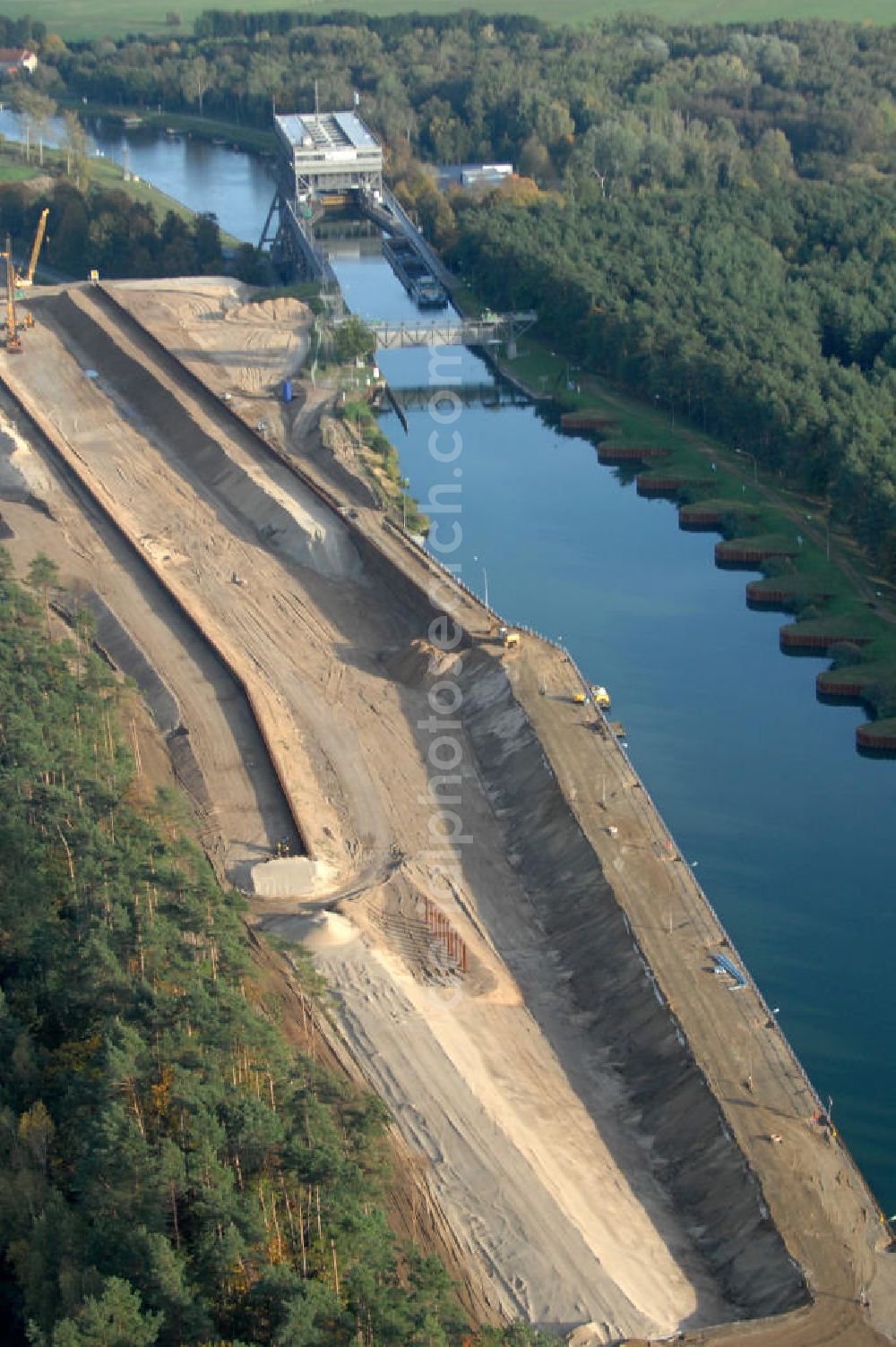 Aerial photograph Niederfinow - Das Wasserstraßen-Neubauamt Berlin den Bauauftrag für den Neubau des Schiffshebewerkes Niederfinow Nord vergeben. Der Zuschlag wurde auf das Angebot der Bietergemeinschaft Neues Schiffshebewerk Niederfinow unter Federführung der Bilfinger Berger AG erteilt. Der Bietergemeinschaft gehören weiter: die DSD Brückenbau GmbH, die Johann Bunte Bauunternehmung GmbH & Co. KG und die Siemag GmbH an. Die geplante Bauzeit für das neue Schiffshebewerk beträgt fünf Jahre, die Baukosten für die Gesamtanlage liegen bei rd. 285 Mio. Euro und werden durch den Bund finanziert. Seit Mitte Februar 2009 wird die Baugrubenumschließung für das neue Schiffshebewerk hergestellt. Es werden 217 Träger und 214 Zwischenbohlen in den Baugrund eingebracht. Die Träger haben eine Länge von ca. 22m und wiegen einzeln etwa 5,7 Tonnen. Die Rüttelarbeiten für die Baugrube werden voraussichtlich bis Ende April andauern.Mit einem Investitionsvolumen von rd. 285. Mio € entsteht in Niederfinow bis zum Jahr 2014 ein neues Schiffshebewerk der europäischen Wasserstraßenklasse V. Der Neubau ist dringend erforderlich, weil das alte Schiffshebewerk aus dem Jahr 1934 bald das Ende seiner Lebensdauer erreicht hat. Um die Funktion der Havel-Oder-Wasserstraße aufrechtzuerhalten, muss es daher planmäßig durch einen Neubau ersetzt werden.