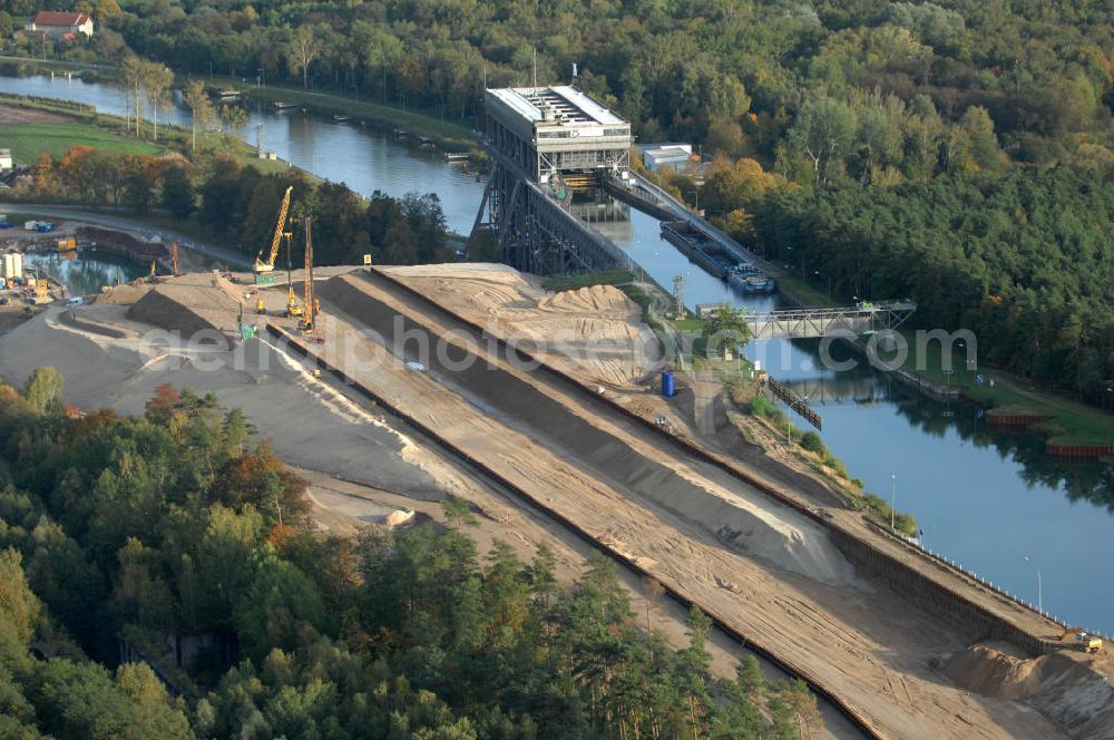 Niederfinow from the bird's eye view: Das Wasserstraßen-Neubauamt Berlin den Bauauftrag für den Neubau des Schiffshebewerkes Niederfinow Nord vergeben. Der Zuschlag wurde auf das Angebot der Bietergemeinschaft Neues Schiffshebewerk Niederfinow unter Federführung der Bilfinger Berger AG erteilt. Der Bietergemeinschaft gehören weiter: die DSD Brückenbau GmbH, die Johann Bunte Bauunternehmung GmbH & Co. KG und die Siemag GmbH an. Die geplante Bauzeit für das neue Schiffshebewerk beträgt fünf Jahre, die Baukosten für die Gesamtanlage liegen bei rd. 285 Mio. Euro und werden durch den Bund finanziert. Seit Mitte Februar 2009 wird die Baugrubenumschließung für das neue Schiffshebewerk hergestellt. Es werden 217 Träger und 214 Zwischenbohlen in den Baugrund eingebracht. Die Träger haben eine Länge von ca. 22m und wiegen einzeln etwa 5,7 Tonnen. Die Rüttelarbeiten für die Baugrube werden voraussichtlich bis Ende April andauern.Mit einem Investitionsvolumen von rd. 285. Mio € entsteht in Niederfinow bis zum Jahr 2014 ein neues Schiffshebewerk der europäischen Wasserstraßenklasse V. Der Neubau ist dringend erforderlich, weil das alte Schiffshebewerk aus dem Jahr 1934 bald das Ende seiner Lebensdauer erreicht hat. Um die Funktion der Havel-Oder-Wasserstraße aufrechtzuerhalten, muss es daher planmäßig durch einen Neubau ersetzt werden.