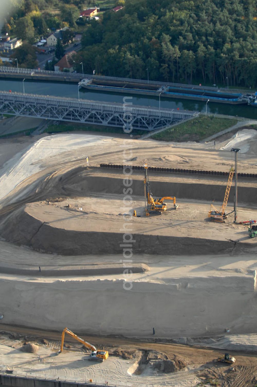 Aerial photograph Niederfinow - Das Wasserstraßen-Neubauamt Berlin den Bauauftrag für den Neubau des Schiffshebewerkes Niederfinow Nord vergeben. Der Zuschlag wurde auf das Angebot der Bietergemeinschaft Neues Schiffshebewerk Niederfinow unter Federführung der Bilfinger Berger AG erteilt. Der Bietergemeinschaft gehören weiter: die DSD Brückenbau GmbH, die Johann Bunte Bauunternehmung GmbH & Co. KG und die Siemag GmbH an. Die geplante Bauzeit für das neue Schiffshebewerk beträgt fünf Jahre, die Baukosten für die Gesamtanlage liegen bei rd. 285 Mio. Euro und werden durch den Bund finanziert. Seit Mitte Februar 2009 wird die Baugrubenumschließung für das neue Schiffshebewerk hergestellt. Es werden 217 Träger und 214 Zwischenbohlen in den Baugrund eingebracht. Die Träger haben eine Länge von ca. 22m und wiegen einzeln etwa 5,7 Tonnen. Die Rüttelarbeiten für die Baugrube werden voraussichtlich bis Ende April andauern.Mit einem Investitionsvolumen von rd. 285. Mio € entsteht in Niederfinow bis zum Jahr 2014 ein neues Schiffshebewerk der europäischen Wasserstraßenklasse V. Der Neubau ist dringend erforderlich, weil das alte Schiffshebewerk aus dem Jahr 1934 bald das Ende seiner Lebensdauer erreicht hat. Um die Funktion der Havel-Oder-Wasserstraße aufrechtzuerhalten, muss es daher planmäßig durch einen Neubau ersetzt werden.