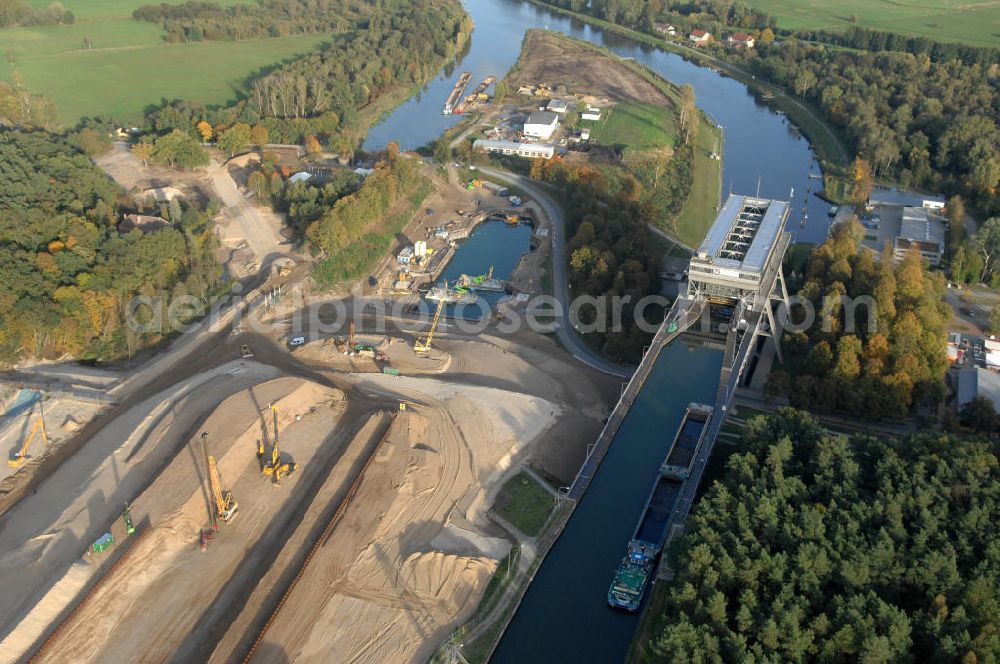 Niederfinow from the bird's eye view: Das Wasserstraßen-Neubauamt Berlin den Bauauftrag für den Neubau des Schiffshebewerkes Niederfinow Nord vergeben. Der Zuschlag wurde auf das Angebot der Bietergemeinschaft Neues Schiffshebewerk Niederfinow unter Federführung der Bilfinger Berger AG erteilt. Der Bietergemeinschaft gehören weiter: die DSD Brückenbau GmbH, die Johann Bunte Bauunternehmung GmbH & Co. KG und die Siemag GmbH an. Die geplante Bauzeit für das neue Schiffshebewerk beträgt fünf Jahre, die Baukosten für die Gesamtanlage liegen bei rd. 285 Mio. Euro und werden durch den Bund finanziert. Seit Mitte Februar 2009 wird die Baugrubenumschließung für das neue Schiffshebewerk hergestellt. Es werden 217 Träger und 214 Zwischenbohlen in den Baugrund eingebracht. Die Träger haben eine Länge von ca. 22m und wiegen einzeln etwa 5,7 Tonnen. Die Rüttelarbeiten für die Baugrube werden voraussichtlich bis Ende April andauern.Mit einem Investitionsvolumen von rd. 285. Mio € entsteht in Niederfinow bis zum Jahr 2014 ein neues Schiffshebewerk der europäischen Wasserstraßenklasse V. Der Neubau ist dringend erforderlich, weil das alte Schiffshebewerk aus dem Jahr 1934 bald das Ende seiner Lebensdauer erreicht hat. Um die Funktion der Havel-Oder-Wasserstraße aufrechtzuerhalten, muss es daher planmäßig durch einen Neubau ersetzt werden.