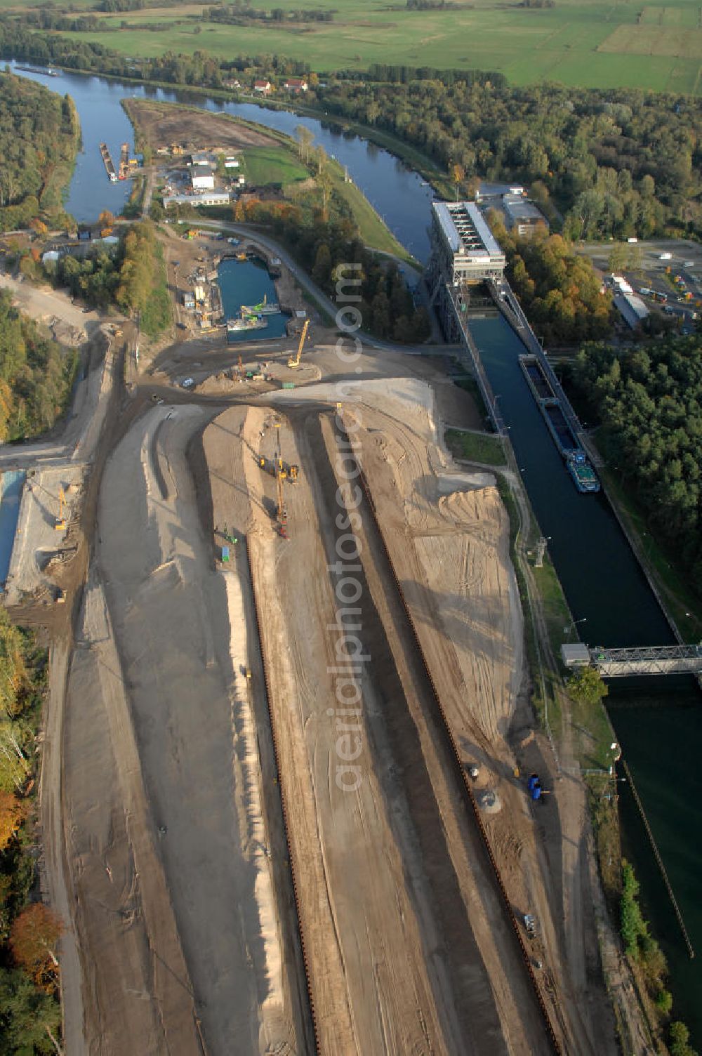 Aerial photograph Niederfinow - Das Wasserstraßen-Neubauamt Berlin den Bauauftrag für den Neubau des Schiffshebewerkes Niederfinow Nord vergeben. Der Zuschlag wurde auf das Angebot der Bietergemeinschaft Neues Schiffshebewerk Niederfinow unter Federführung der Bilfinger Berger AG erteilt. Der Bietergemeinschaft gehören weiter: die DSD Brückenbau GmbH, die Johann Bunte Bauunternehmung GmbH & Co. KG und die Siemag GmbH an. Die geplante Bauzeit für das neue Schiffshebewerk beträgt fünf Jahre, die Baukosten für die Gesamtanlage liegen bei rd. 285 Mio. Euro und werden durch den Bund finanziert. Seit Mitte Februar 2009 wird die Baugrubenumschließung für das neue Schiffshebewerk hergestellt. Es werden 217 Träger und 214 Zwischenbohlen in den Baugrund eingebracht. Die Träger haben eine Länge von ca. 22m und wiegen einzeln etwa 5,7 Tonnen. Die Rüttelarbeiten für die Baugrube werden voraussichtlich bis Ende April andauern.Mit einem Investitionsvolumen von rd. 285. Mio € entsteht in Niederfinow bis zum Jahr 2014 ein neues Schiffshebewerk der europäischen Wasserstraßenklasse V. Der Neubau ist dringend erforderlich, weil das alte Schiffshebewerk aus dem Jahr 1934 bald das Ende seiner Lebensdauer erreicht hat. Um die Funktion der Havel-Oder-Wasserstraße aufrechtzuerhalten, muss es daher planmäßig durch einen Neubau ersetzt werden.