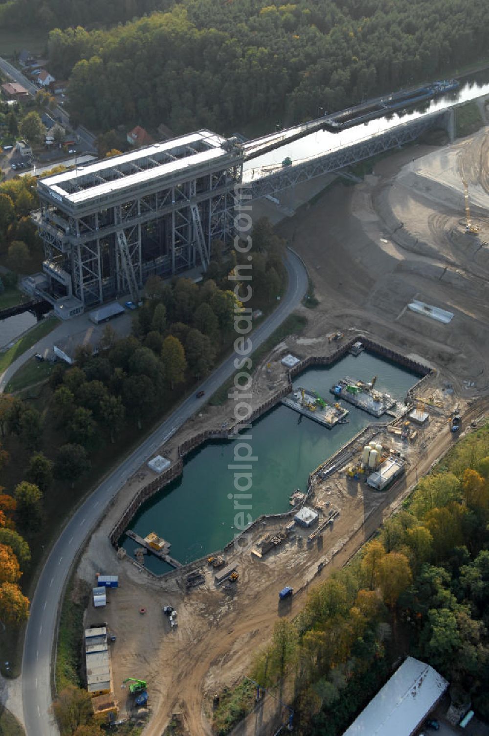 Niederfinow from the bird's eye view: Das Wasserstraßen-Neubauamt Berlin den Bauauftrag für den Neubau des Schiffshebewerkes Niederfinow Nord vergeben. Der Zuschlag wurde auf das Angebot der Bietergemeinschaft Neues Schiffshebewerk Niederfinow unter Federführung der Bilfinger Berger AG erteilt. Der Bietergemeinschaft gehören weiter: die DSD Brückenbau GmbH, die Johann Bunte Bauunternehmung GmbH & Co. KG und die Siemag GmbH an. Die geplante Bauzeit für das neue Schiffshebewerk beträgt fünf Jahre, die Baukosten für die Gesamtanlage liegen bei rd. 285 Mio. Euro und werden durch den Bund finanziert. Seit Mitte Februar 2009 wird die Baugrubenumschließung für das neue Schiffshebewerk hergestellt. Es werden 217 Träger und 214 Zwischenbohlen in den Baugrund eingebracht. Die Träger haben eine Länge von ca. 22m und wiegen einzeln etwa 5,7 Tonnen. Die Rüttelarbeiten für die Baugrube werden voraussichtlich bis Ende April andauern.Mit einem Investitionsvolumen von rd. 285. Mio € entsteht in Niederfinow bis zum Jahr 2014 ein neues Schiffshebewerk der europäischen Wasserstraßenklasse V. Der Neubau ist dringend erforderlich, weil das alte Schiffshebewerk aus dem Jahr 1934 bald das Ende seiner Lebensdauer erreicht hat. Um die Funktion der Havel-Oder-Wasserstraße aufrechtzuerhalten, muss es daher planmäßig durch einen Neubau ersetzt werden.