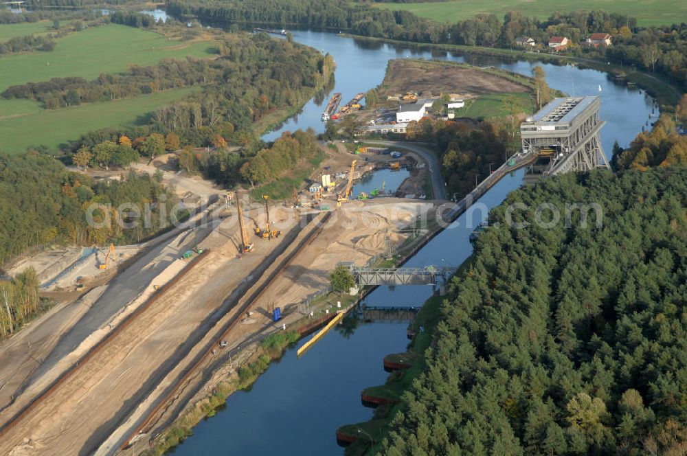 Niederfinow from the bird's eye view: Das Wasserstraßen-Neubauamt Berlin den Bauauftrag für den Neubau des Schiffshebewerkes Niederfinow Nord vergeben. Der Zuschlag wurde auf das Angebot der Bietergemeinschaft Neues Schiffshebewerk Niederfinow unter Federführung der Bilfinger Berger AG erteilt. Der Bietergemeinschaft gehören weiter: die DSD Brückenbau GmbH, die Johann Bunte Bauunternehmung GmbH & Co. KG und die Siemag GmbH an. Die geplante Bauzeit für das neue Schiffshebewerk beträgt fünf Jahre, die Baukosten für die Gesamtanlage liegen bei rd. 285 Mio. Euro und werden durch den Bund finanziert. Seit Mitte Februar 2009 wird die Baugrubenumschließung für das neue Schiffshebewerk hergestellt. Es werden 217 Träger und 214 Zwischenbohlen in den Baugrund eingebracht. Die Träger haben eine Länge von ca. 22m und wiegen einzeln etwa 5,7 Tonnen. Die Rüttelarbeiten für die Baugrube werden voraussichtlich bis Ende April andauern.Mit einem Investitionsvolumen von rd. 285. Mio € entsteht in Niederfinow bis zum Jahr 2014 ein neues Schiffshebewerk der europäischen Wasserstraßenklasse V. Der Neubau ist dringend erforderlich, weil das alte Schiffshebewerk aus dem Jahr 1934 bald das Ende seiner Lebensdauer erreicht hat. Um die Funktion der Havel-Oder-Wasserstraße aufrechtzuerhalten, muss es daher planmäßig durch einen Neubau ersetzt werden.