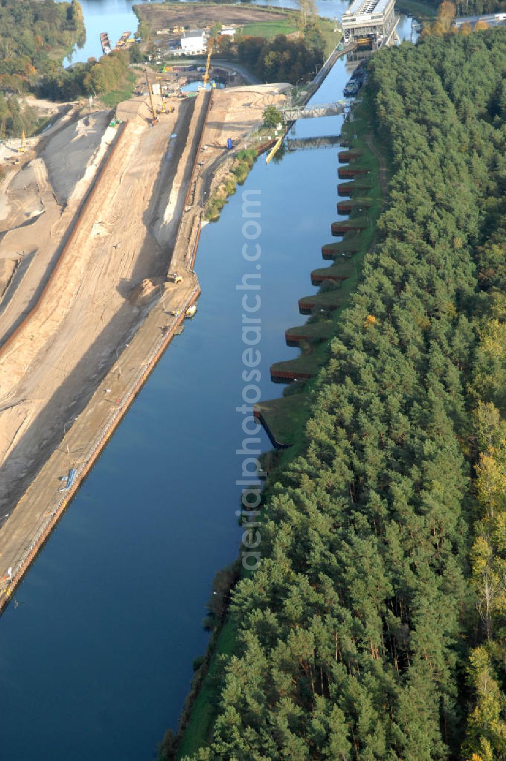 Aerial photograph Niederfinow - Das Wasserstraßen-Neubauamt Berlin den Bauauftrag für den Neubau des Schiffshebewerkes Niederfinow Nord vergeben. Der Zuschlag wurde auf das Angebot der Bietergemeinschaft Neues Schiffshebewerk Niederfinow unter Federführung der Bilfinger Berger AG erteilt. Der Bietergemeinschaft gehören weiter: die DSD Brückenbau GmbH, die Johann Bunte Bauunternehmung GmbH & Co. KG und die Siemag GmbH an. Die geplante Bauzeit für das neue Schiffshebewerk beträgt fünf Jahre, die Baukosten für die Gesamtanlage liegen bei rd. 285 Mio. Euro und werden durch den Bund finanziert. Seit Mitte Februar 2009 wird die Baugrubenumschließung für das neue Schiffshebewerk hergestellt. Es werden 217 Träger und 214 Zwischenbohlen in den Baugrund eingebracht. Die Träger haben eine Länge von ca. 22m und wiegen einzeln etwa 5,7 Tonnen. Die Rüttelarbeiten für die Baugrube werden voraussichtlich bis Ende April andauern.Mit einem Investitionsvolumen von rd. 285. Mio € entsteht in Niederfinow bis zum Jahr 2014 ein neues Schiffshebewerk der europäischen Wasserstraßenklasse V. Der Neubau ist dringend erforderlich, weil das alte Schiffshebewerk aus dem Jahr 1934 bald das Ende seiner Lebensdauer erreicht hat. Um die Funktion der Havel-Oder-Wasserstraße aufrechtzuerhalten, muss es daher planmäßig durch einen Neubau ersetzt werden.