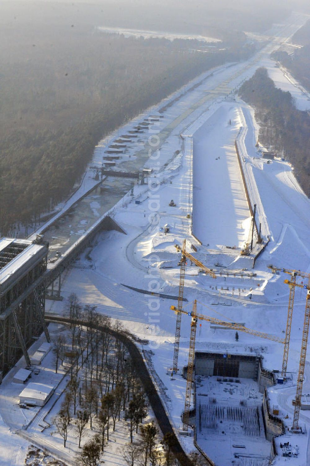 Aerial photograph Niederfinow - Blick auf die winterlich verschneite Baustelle des Neubaus des Schiffshebewerkes Niederfinow Nord durch die DSD Brückenbau GmbH, die Johann Bunte Bauunternehmung GmbH & Co. KG , Bilfinger Berger Ingenieurbau GmbH und die Siemag GmbH. Look at the new building of the boat lift Niederfinow North Bridge. The new building needed because the old boat lift of 1934 has now reached the end of its life. To maintain the function of the Havel-Oder waterway, it must therefore be replaced by a new building on schedule.