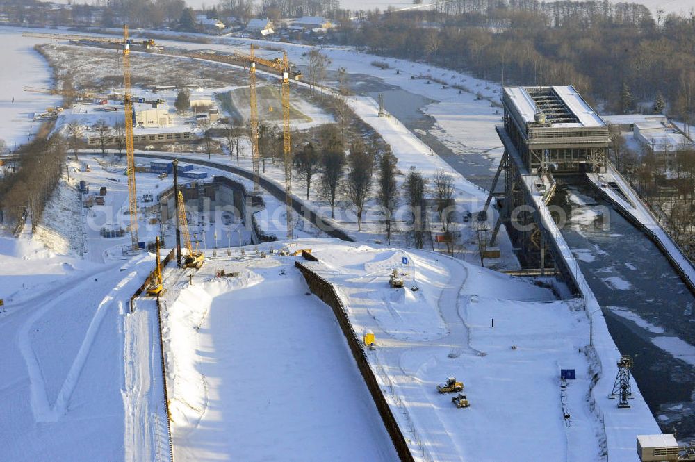 Aerial photograph Niederfinow - Blick auf die winterlich verschneite Baustelle des Neubaus des Schiffshebewerkes Niederfinow Nord durch die DSD Brückenbau GmbH, die Johann Bunte Bauunternehmung GmbH & Co. KG , Bilfinger Berger Ingenieurbau GmbH und die Siemag GmbH. Look at the new building of the boat lift Niederfinow North Bridge. The new building needed because the old boat lift of 1934 has now reached the end of its life. To maintain the function of the Havel-Oder waterway, it must therefore be replaced by a new building on schedule.