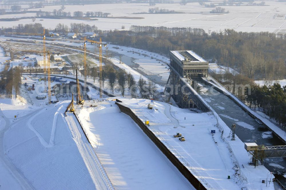 Aerial photograph Niederfinow - Blick auf die winterlich verschneite Baustelle des Neubaus des Schiffshebewerkes Niederfinow Nord durch die DSD Brückenbau GmbH, die Johann Bunte Bauunternehmung GmbH & Co. KG , Bilfinger Berger Ingenieurbau GmbH und die Siemag GmbH. Look at the new building of the boat lift Niederfinow North Bridge. The new building needed because the old boat lift of 1934 has now reached the end of its life. To maintain the function of the Havel-Oder waterway, it must therefore be replaced by a new building on schedule.