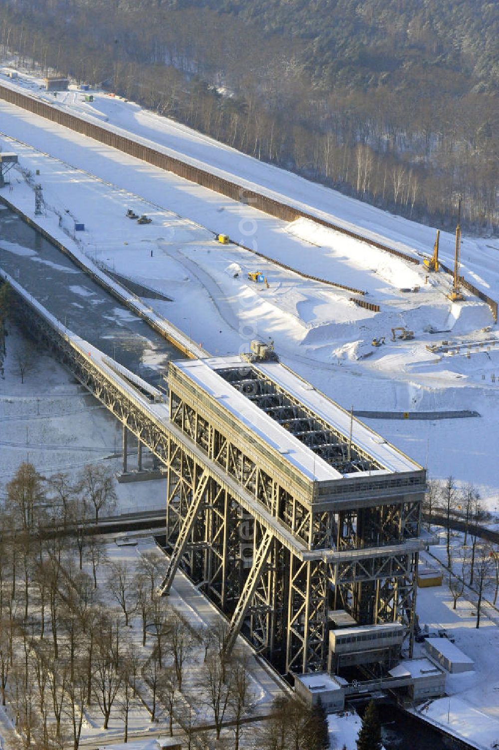 Aerial photograph Niederfinow - Blick auf die winterlich verschneite Baustelle des Neubaus des Schiffshebewerkes Niederfinow Nord durch die DSD Brückenbau GmbH, die Johann Bunte Bauunternehmung GmbH & Co. KG , Bilfinger Berger Ingenieurbau GmbH und die Siemag GmbH. Look at the new building of the boat lift Niederfinow North Bridge. The new building needed because the old boat lift of 1934 has now reached the end of its life. To maintain the function of the Havel-Oder waterway, it must therefore be replaced by a new building on schedule.