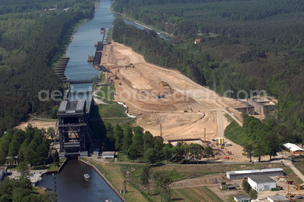 Aerial image NIEDERFINOW - Das Wasserstraßen-Neubauamt Berlin den Bauauftrag für den Neubau des Schiffshebewerkes Niederfinow Nord vergeben. Der Zuschlag wurde auf das Angebot der Bietergemeinschaft Neues Schiffshebewerk Niederfinow unter Federführung der Bilfinger Berger AG erteilt. Der Bietergemeinschaft gehören weiter: die DSD Brückenbau GmbH, die Johann Bunte Bauunternehmung GmbH & Co. KG und die Siemag GmbH an. Die geplante Bauzeit für das neue Schiffshebewerk beträgt fünf Jahre, die Baukosten für die Gesamtanlage liegen bei rd. 285 Mio. Euro und werden durch den Bund finanziert. Seit Mitte Februar 2009 wird die Baugrubenumschließung für das neue Schiffshebewerk hergestellt. Es werden 217 Träger und 214 Zwischenbohlen in den Baugrund eingebracht. Die Träger haben eine Länge von ca. 22m und wiegen einzeln etwa 5,7 Tonnen. Die Rüttelarbeiten für die Baugrube werden voraussichtlich bis Ende April andauern.Mit einem Investitionsvolumen von rd. 285. Mio € entsteht in Niederfinow bis zum Jahr 2014 ein neues Schiffshebewerk der europäischen Wasserstraßenklasse V. Der Neubau ist dringend erforderlich, weil das alte Schiffshebewerk aus dem Jahr 1934 bald das Ende seiner Lebensdauer erreicht hat. Um die Funktion der Havel-Oder-Wasserstraße aufrechtzuerhalten, muss es daher planmäßig durch einen Neubau ersetzt werden.