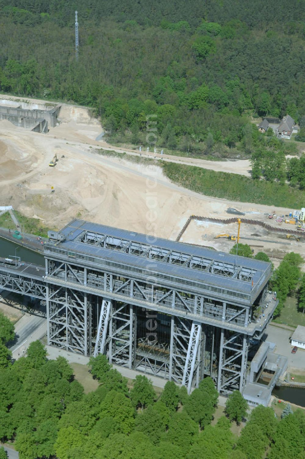 NIEDERFINOW from above - Das Wasserstraßen-Neubauamt Berlin den Bauauftrag für den Neubau des Schiffshebewerkes Niederfinow Nord vergeben. Der Zuschlag wurde auf das Angebot der Bietergemeinschaft Neues Schiffshebewerk Niederfinow unter Federführung der Bilfinger Berger AG erteilt. Der Bietergemeinschaft gehören weiter: die DSD Brückenbau GmbH, die Johann Bunte Bauunternehmung GmbH & Co. KG und die Siemag GmbH an. Die geplante Bauzeit für das neue Schiffshebewerk beträgt fünf Jahre, die Baukosten für die Gesamtanlage liegen bei rd. 285 Mio. Euro und werden durch den Bund finanziert. Seit Mitte Februar 2009 wird die Baugrubenumschließung für das neue Schiffshebewerk hergestellt. Es werden 217 Träger und 214 Zwischenbohlen in den Baugrund eingebracht. Die Träger haben eine Länge von ca. 22m und wiegen einzeln etwa 5,7 Tonnen. Die Rüttelarbeiten für die Baugrube werden voraussichtlich bis Ende April andauern.Mit einem Investitionsvolumen von rd. 285. Mio € entsteht in Niederfinow bis zum Jahr 2014 ein neues Schiffshebewerk der europäischen Wasserstraßenklasse V. Der Neubau ist dringend erforderlich, weil das alte Schiffshebewerk aus dem Jahr 1934 bald das Ende seiner Lebensdauer erreicht hat. Um die Funktion der Havel-Oder-Wasserstraße aufrechtzuerhalten, muss es daher planmäßig durch einen Neubau ersetzt werden.