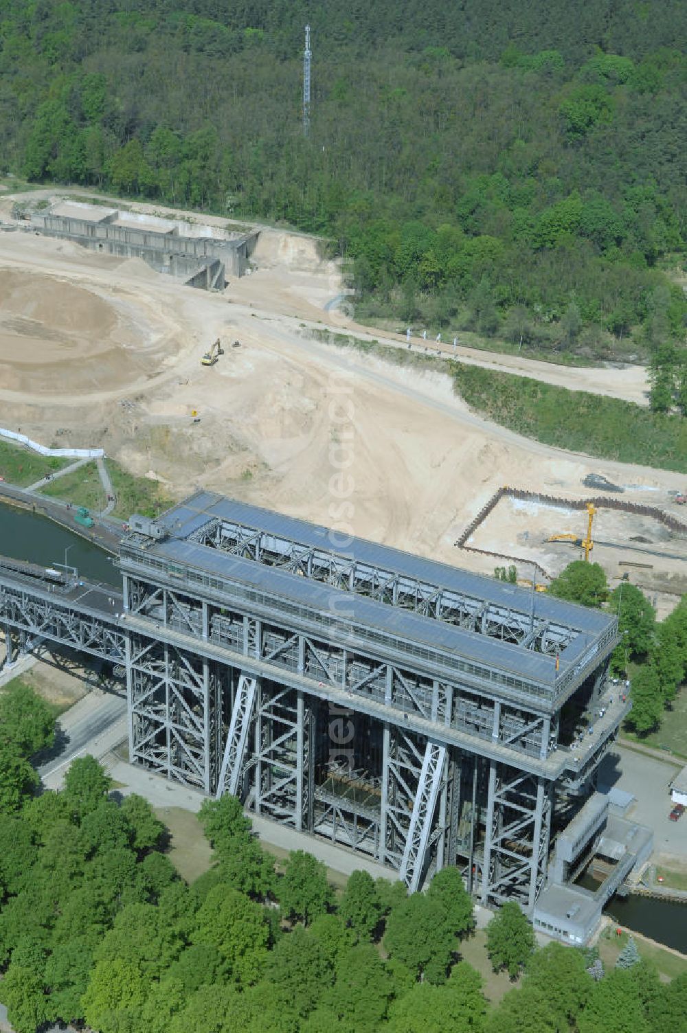 NIEDERFINOW from the bird's eye view: Das Wasserstraßen-Neubauamt Berlin den Bauauftrag für den Neubau des Schiffshebewerkes Niederfinow Nord vergeben. Der Zuschlag wurde auf das Angebot der Bietergemeinschaft Neues Schiffshebewerk Niederfinow unter Federführung der Bilfinger Berger AG erteilt. Der Bietergemeinschaft gehören weiter: die DSD Brückenbau GmbH, die Johann Bunte Bauunternehmung GmbH & Co. KG und die Siemag GmbH an. Die geplante Bauzeit für das neue Schiffshebewerk beträgt fünf Jahre, die Baukosten für die Gesamtanlage liegen bei rd. 285 Mio. Euro und werden durch den Bund finanziert. Seit Mitte Februar 2009 wird die Baugrubenumschließung für das neue Schiffshebewerk hergestellt. Es werden 217 Träger und 214 Zwischenbohlen in den Baugrund eingebracht. Die Träger haben eine Länge von ca. 22m und wiegen einzeln etwa 5,7 Tonnen. Die Rüttelarbeiten für die Baugrube werden voraussichtlich bis Ende April andauern.Mit einem Investitionsvolumen von rd. 285. Mio € entsteht in Niederfinow bis zum Jahr 2014 ein neues Schiffshebewerk der europäischen Wasserstraßenklasse V. Der Neubau ist dringend erforderlich, weil das alte Schiffshebewerk aus dem Jahr 1934 bald das Ende seiner Lebensdauer erreicht hat. Um die Funktion der Havel-Oder-Wasserstraße aufrechtzuerhalten, muss es daher planmäßig durch einen Neubau ersetzt werden.