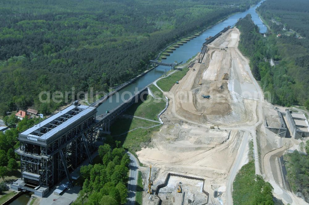 NIEDERFINOW from above - Das Wasserstraßen-Neubauamt Berlin den Bauauftrag für den Neubau des Schiffshebewerkes Niederfinow Nord vergeben. Der Zuschlag wurde auf das Angebot der Bietergemeinschaft Neues Schiffshebewerk Niederfinow unter Federführung der Bilfinger Berger AG erteilt. Der Bietergemeinschaft gehören weiter: die DSD Brückenbau GmbH, die Johann Bunte Bauunternehmung GmbH & Co. KG und die Siemag GmbH an. Die geplante Bauzeit für das neue Schiffshebewerk beträgt fünf Jahre, die Baukosten für die Gesamtanlage liegen bei rd. 285 Mio. Euro und werden durch den Bund finanziert. Seit Mitte Februar 2009 wird die Baugrubenumschließung für das neue Schiffshebewerk hergestellt. Es werden 217 Träger und 214 Zwischenbohlen in den Baugrund eingebracht. Die Träger haben eine Länge von ca. 22m und wiegen einzeln etwa 5,7 Tonnen. Die Rüttelarbeiten für die Baugrube werden voraussichtlich bis Ende April andauern.Mit einem Investitionsvolumen von rd. 285. Mio € entsteht in Niederfinow bis zum Jahr 2014 ein neues Schiffshebewerk der europäischen Wasserstraßenklasse V. Der Neubau ist dringend erforderlich, weil das alte Schiffshebewerk aus dem Jahr 1934 bald das Ende seiner Lebensdauer erreicht hat. Um die Funktion der Havel-Oder-Wasserstraße aufrechtzuerhalten, muss es daher planmäßig durch einen Neubau ersetzt werden.