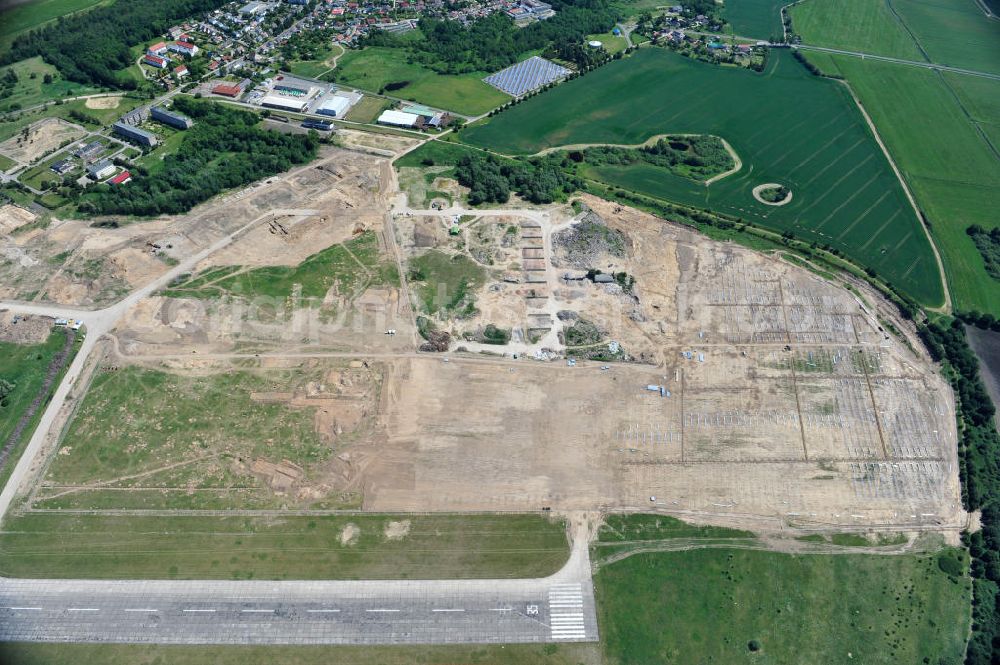 Tutow from above - Neuer Bauabschnitt des Solarenergiepark am Flugplatz Tutow in Mecklenburg - Vorpommern. Die juwi solar GmbH errichtet hier auf ca. 21 Hektar einen Solarpark mit ca. 65.500 Quadratmetern Solarmodulfläche bei ca. 91.000200 Einzelmodulen und einer Nennleistung von ca. 6780 Kilowattstunden jährlich. Modulhersteller ist die First Solar GmbH, die Unterkonstruktionen werden von der Fa. Schletter Leichtmetallbau GmbH errichtet. View of the second section of the solar energy park at the airport Tutow in Mecklenburg - Western Pomerania.