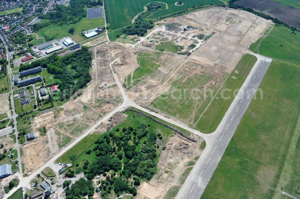 Tutow from the bird's eye view: Neuer Bauabschnitt des Solarenergiepark am Flugplatz Tutow in Mecklenburg - Vorpommern. Die juwi solar GmbH errichtet hier auf ca. 21 Hektar einen Solarpark mit ca. 65.500 Quadratmetern Solarmodulfläche bei ca. 91.000200 Einzelmodulen und einer Nennleistung von ca. 6780 Kilowattstunden jährlich. Modulhersteller ist die First Solar GmbH, die Unterkonstruktionen werden von der Fa. Schletter Leichtmetallbau GmbH errichtet. View of the second section of the solar energy park at the airport Tutow in Mecklenburg - Western Pomerania.