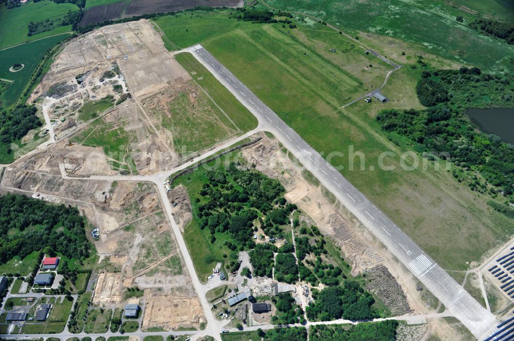 Tutow from the bird's eye view: Neuer Bauabschnitt des Solarenergiepark am Flugplatz Tutow in Mecklenburg - Vorpommern. Die juwi solar GmbH errichtet hier auf ca. 21 Hektar einen Solarpark mit ca. 65.500 Quadratmetern Solarmodulfläche bei ca. 91.000200 Einzelmodulen und einer Nennleistung von ca. 6780 Kilowattstunden jährlich. Modulhersteller ist die First Solar GmbH, die Unterkonstruktionen werden von der Fa. Schletter Leichtmetallbau GmbH errichtet. View of the second section of the solar energy park at the airport Tutow in Mecklenburg - Western Pomerania.