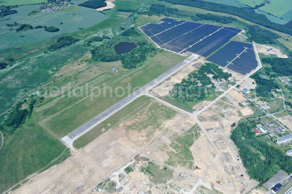 Tutow from the bird's eye view: Neuer Bauabschnitt des Solarenergiepark am Flugplatz Tutow in Mecklenburg - Vorpommern. Die juwi solar GmbH errichtet hier auf ca. 21 Hektar einen Solarpark mit ca. 65.500 Quadratmetern Solarmodulfläche bei ca. 91.000200 Einzelmodulen und einer Nennleistung von ca. 6780 Kilowattstunden jährlich. Modulhersteller ist die First Solar GmbH, die Unterkonstruktionen werden von der Fa. Schletter Leichtmetallbau GmbH errichtet. View of the second section of the solar energy park at the airport Tutow in Mecklenburg - Western Pomerania.