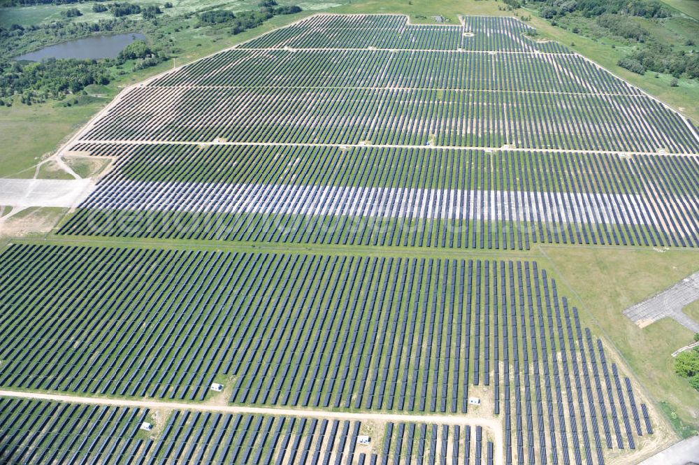 Tutow from the bird's eye view: Neuer Bauabschnitt des Solarenergiepark am Flugplatz Tutow in Mecklenburg - Vorpommern. Die juwi solar GmbH errichtet hier auf ca. 21 Hektar einen Solarpark mit ca. 65.500 Quadratmetern Solarmodulfläche bei ca. 91.000200 Einzelmodulen und einer Nennleistung von ca. 6780 Kilowattstunden jährlich. Modulhersteller ist die First Solar GmbH, die Unterkonstruktionen werden von der Fa. Schletter Leichtmetallbau GmbH errichtet. View of the second section of the solar energy park at the airport Tutow in Mecklenburg - Western Pomerania.