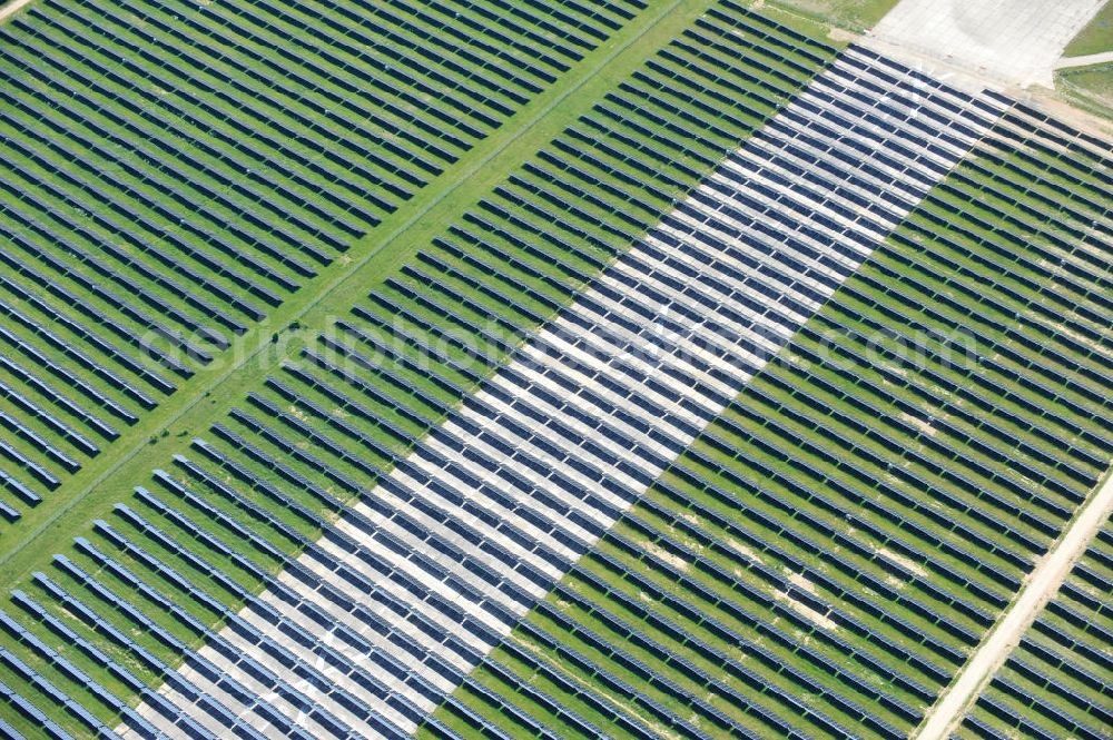 Tutow from the bird's eye view: Neuer Bauabschnitt des Solarenergiepark am Flugplatz Tutow in Mecklenburg - Vorpommern. Die juwi solar GmbH errichtet hier auf ca. 21 Hektar einen Solarpark mit ca. 65.500 Quadratmetern Solarmodulfläche bei ca. 91.000200 Einzelmodulen und einer Nennleistung von ca. 6780 Kilowattstunden jährlich. Modulhersteller ist die First Solar GmbH, die Unterkonstruktionen werden von der Fa. Schletter Leichtmetallbau GmbH errichtet. View of the second section of the solar energy park at the airport Tutow in Mecklenburg - Western Pomerania.