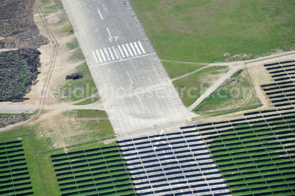 Tutow from the bird's eye view: Neuer Bauabschnitt des Solarenergiepark am Flugplatz Tutow in Mecklenburg - Vorpommern. Die juwi solar GmbH errichtet hier auf ca. 21 Hektar einen Solarpark mit ca. 65.500 Quadratmetern Solarmodulfläche bei ca. 91.000200 Einzelmodulen und einer Nennleistung von ca. 6780 Kilowattstunden jährlich. Modulhersteller ist die First Solar GmbH, die Unterkonstruktionen werden von der Fa. Schletter Leichtmetallbau GmbH errichtet. View of the second section of the solar energy park at the airport Tutow in Mecklenburg - Western Pomerania.