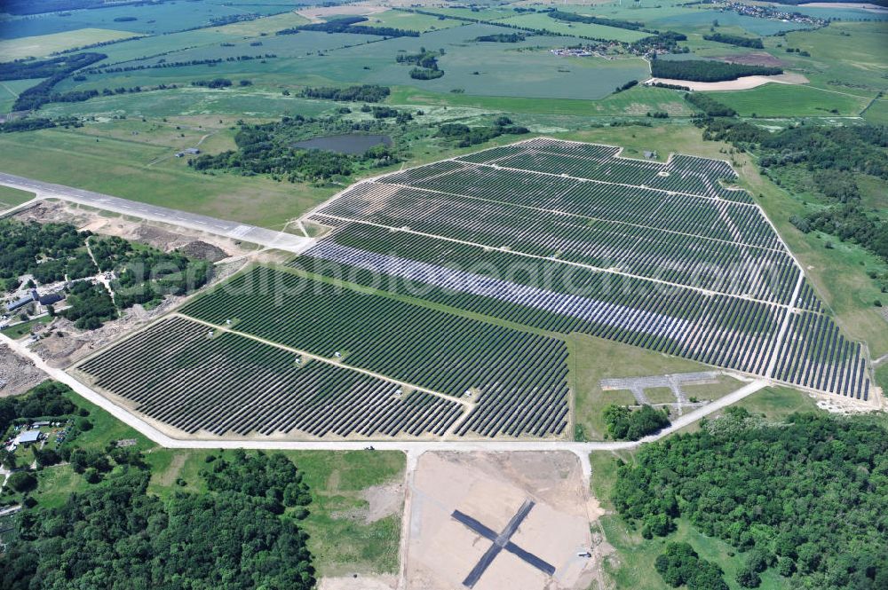 Tutow from the bird's eye view: Neuer Bauabschnitt des Solarenergiepark am Flugplatz Tutow in Mecklenburg - Vorpommern. Die juwi solar GmbH errichtet hier auf ca. 21 Hektar einen Solarpark mit ca. 65.500 Quadratmetern Solarmodulfläche bei ca. 91.000200 Einzelmodulen und einer Nennleistung von ca. 6780 Kilowattstunden jährlich. Modulhersteller ist die First Solar GmbH, die Unterkonstruktionen werden von der Fa. Schletter Leichtmetallbau GmbH errichtet. View of the second section of the solar energy park at the airport Tutow in Mecklenburg - Western Pomerania.