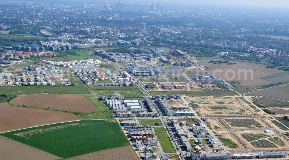 Aerial photograph Frankfurt am Main - Blick auf das Wohngebiet und die Science City des neu entstehenden Stadtbezirkes Riedberg und das Zentrum von Frankfurt am Main in Hessen. Im Nordwesten der Mainmetropole wächst der neue Stadtteil Riedberg mit Ein- und Mehrfamilienhäusern, Wohnungen, Geschäften, Parks, Restaurants, Büros, Kindereinrichtungen, Schulen, Arztpraxen, Hotels und Dienstleistungsbetrieben. Bis zum Jahr 2017 soll die Großsiedlung ca. 6000 Wohneinheiten mit rund 15.000 Einwohnern haben. In der Riedberger Science City mit dem Universitätscampus der Johann Wolfgang Goethe- Universität und seinen angegliederten Instituten, Zentren und Firmen sollen viele Arbeitsplätze entstehen. Construction of Riedberg district on the outskirts of Frankfurt am Main.