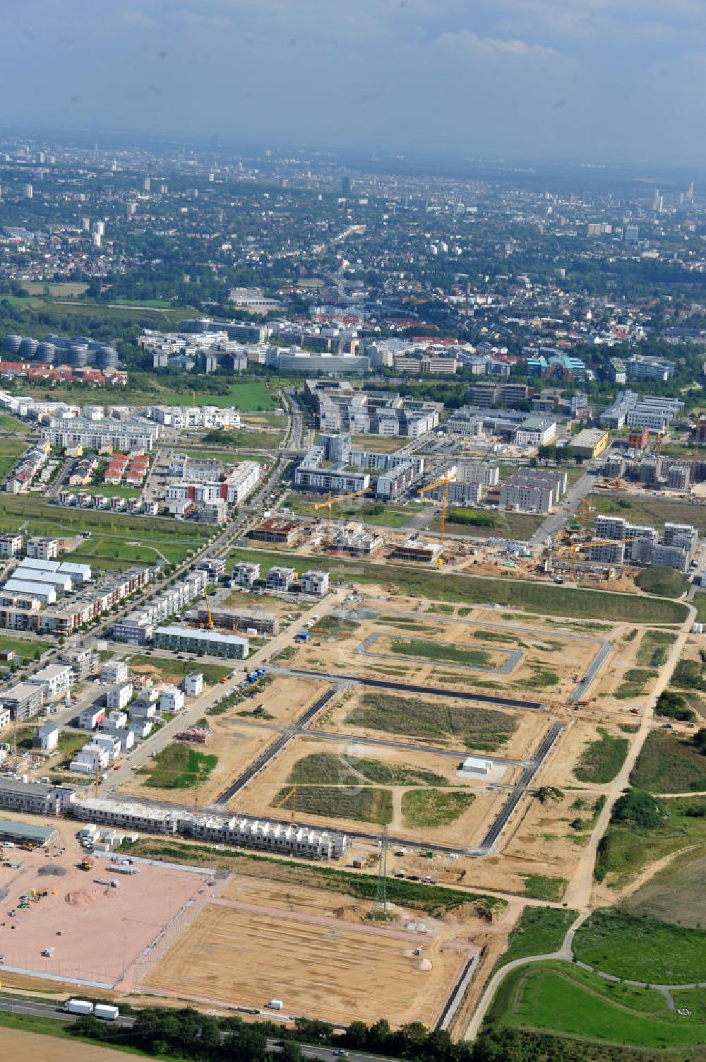 Aerial photograph Frankfurt am Main - Blick auf das Wohngebiet und die Science City des neu entstehenden Stadtbezirkes Riedberg und das Zentrum von Frankfurt am Main in Hessen. Im Nordwesten der Mainmetropole wächst der neue Stadtteil Riedberg mit Ein- und Mehrfamilienhäusern, Wohnungen, Geschäften, Parks, Restaurants, Büros, Kindereinrichtungen, Schulen, Arztpraxen, Hotels und Dienstleistungsbetrieben. Bis zum Jahr 2017 soll die Großsiedlung ca. 6000 Wohneinheiten mit rund 15.000 Einwohnern haben. In der Riedberger Science City mit dem Universitätscampus der Johann Wolfgang Goethe- Universität und seinen angegliederten Instituten, Zentren und Firmen sollen viele Arbeitsplätze entstehen. Construction of Riedberg district on the outskirts of Frankfurt am Main.