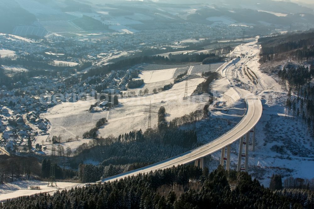 Bestwig from the bird's eye view: Wintry snowy viaduct Nuttlar under construction overlooking the municipality Bestwig in North Rhine-Westphalia