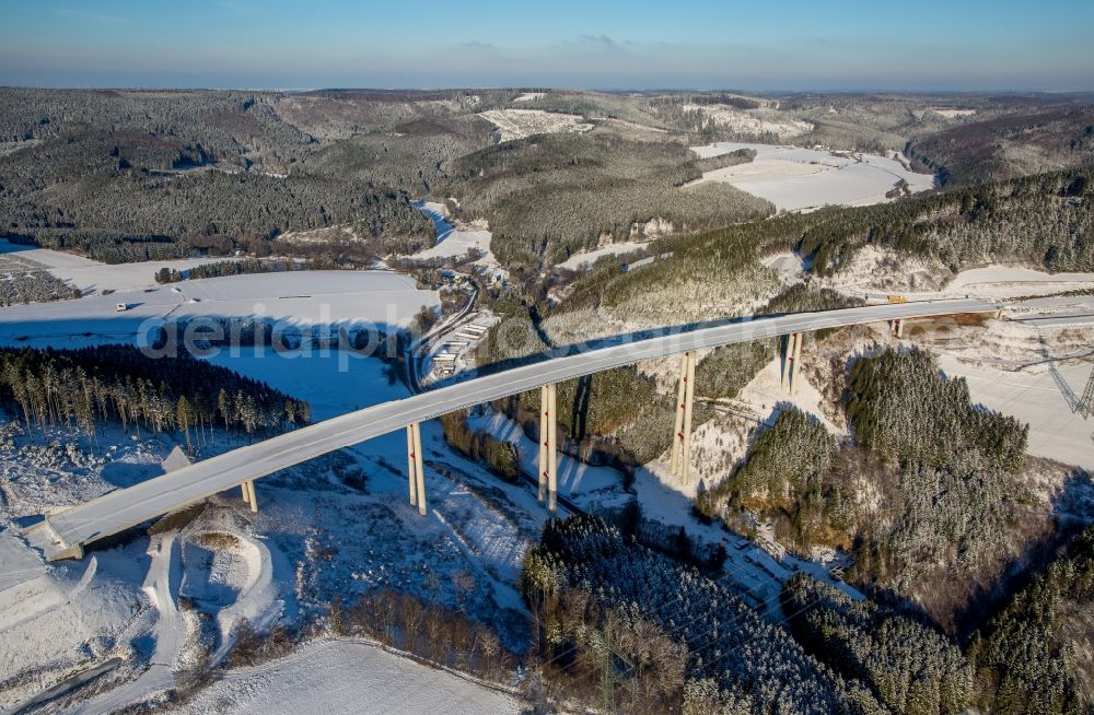 Bestwig from the bird's eye view: Wintry snowy viaduct Nuttlar under construction overlooking the municipality Bestwig in North Rhine-Westphalia