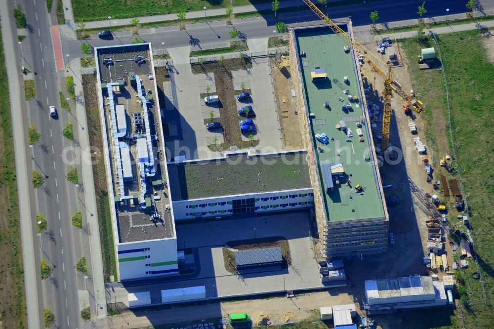 Aerial photograph Berlin - Construction site in the technology park of Adlershof in the Treptow-Koepenick district of Berlin in Germany. Adlershof consists of the technology park and industrial area and wide green areas and residential estates. Elaborate architecture is characteristic for the economy location and is currently created on Newtonstrasse