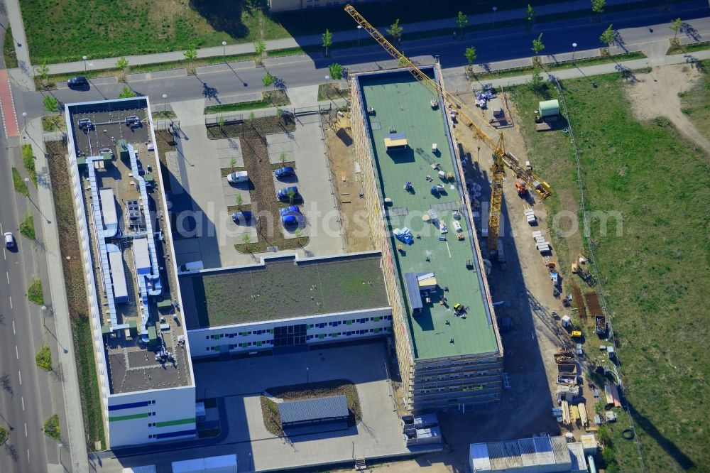 Aerial image Berlin - Construction site in the technology park of Adlershof in the Treptow-Koepenick district of Berlin in Germany. Adlershof consists of the technology park and industrial area and wide green areas and residential estates. Elaborate architecture is characteristic for the economy location and is currently created on Newtonstrasse