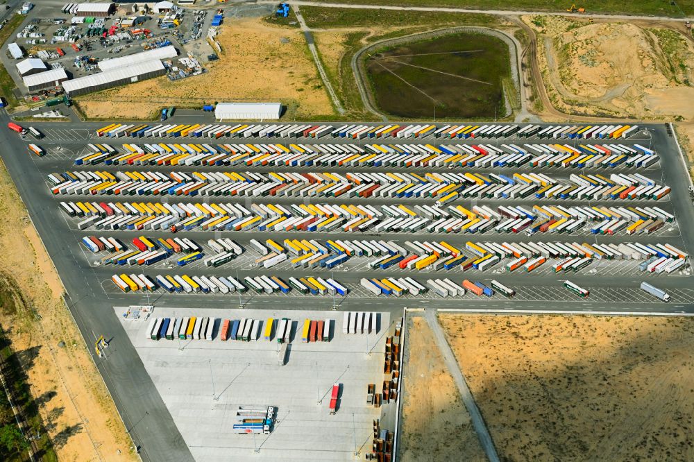 Grünheide (Mark) from above - Truck - semi-trailer wagons for loading and unloading in the parking lot of the Tesla Gigafactory 4 on Schlehenweg - Eichenstrasse in the district of Freienbrink in Gruenheide (Mark) in the federal state of Brandenburg, Germany