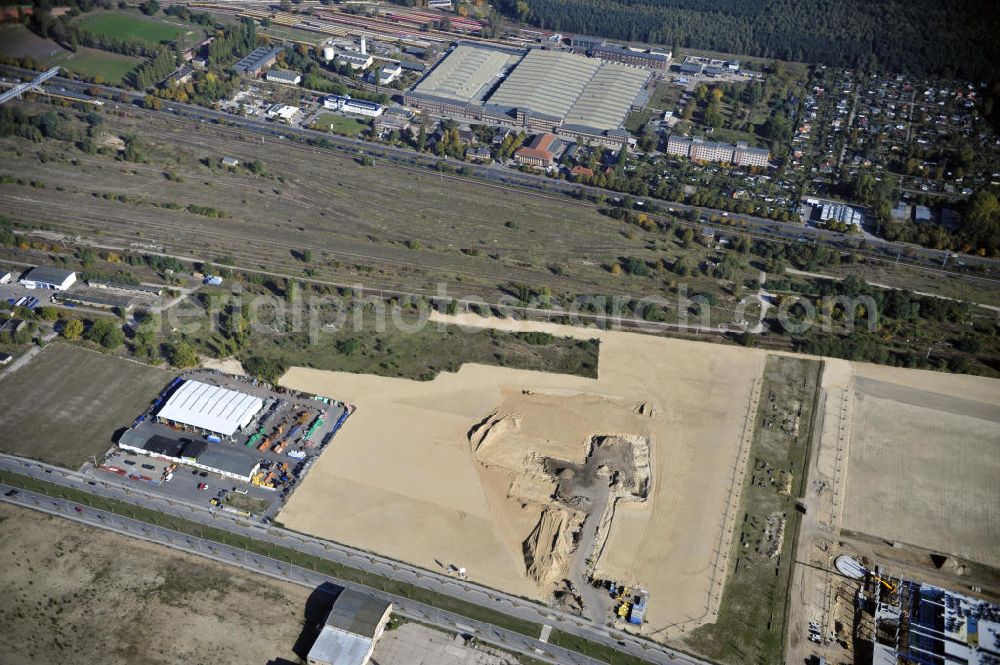 Aerial photograph Berlin - Blick auf eine Planfläche im Gewerbegebiet Flugplatz Johannisthal am Groß-Berliner Damm. Das Gelände dient heute als Baufläche für Einfamilienhäuser und als Gewerbegebiet. Des weiteren befindet sich heute auf dem Gelände unter an derem der Aerodynamische Park als Teil des Campus der Humboldt-Universität zu Berlin. Der Name des Platzes weist auf den besonderen Charakter und die historische wie architektonische Bedeutung durch die prägnanten und dominierenden Baudenkmale der ehemaligen Deutschen Versuchsanstalt für Luftfahrt e.V. hin. Das mittlerweile entstandene grüne Biotop auf der Fläche der ehemaligen Start- und Landebahn ist in eine Parklandschaft integriert worden, dem Europapark, der nach einem Wettbewerb seit den späten 1990er Jahren hier entsteht. View onto the construction site at the industrial area at the former airport Johannisthal. Today the area serves as ab building area and as an industrial area.