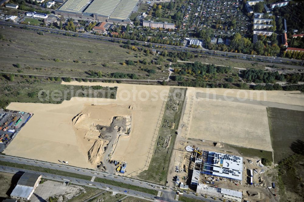 Berlin from the bird's eye view: Blick auf eine Planfläche im Gewerbegebiet Flugplatz Johannisthal am Groß-Berliner Damm. Das Gelände dient heute als Baufläche für Einfamilienhäuser und als Gewerbegebiet. Des weiteren befindet sich heute auf dem Gelände unter an derem der Aerodynamische Park als Teil des Campus der Humboldt-Universität zu Berlin. Der Name des Platzes weist auf den besonderen Charakter und die historische wie architektonische Bedeutung durch die prägnanten und dominierenden Baudenkmale der ehemaligen Deutschen Versuchsanstalt für Luftfahrt e.V. hin. Das mittlerweile entstandene grüne Biotop auf der Fläche der ehemaligen Start- und Landebahn ist in eine Parklandschaft integriert worden, dem Europapark, der nach einem Wettbewerb seit den späten 1990er Jahren hier entsteht. View onto the construction site at the industrial area at the former airport Johannisthal. Today the area serves as ab building area and as an industrial area.