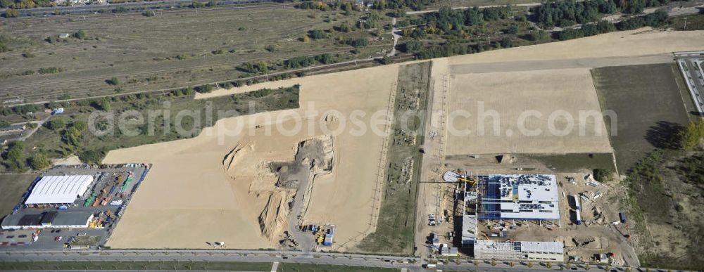 Aerial image Berlin - Blick auf eine Planfläche im Gewerbegebiet Flugplatz Johannisthal am Groß-Berliner Damm. Das Gelände dient heute als Baufläche für Einfamilienhäuser und als Gewerbegebiet. Des weiteren befindet sich heute auf dem Gelände unter an derem der Aerodynamische Park als Teil des Campus der Humboldt-Universität zu Berlin. Der Name des Platzes weist auf den besonderen Charakter und die historische wie architektonische Bedeutung durch die prägnanten und dominierenden Baudenkmale der ehemaligen Deutschen Versuchsanstalt für Luftfahrt e.V. hin. Das mittlerweile entstandene grüne Biotop auf der Fläche der ehemaligen Start- und Landebahn ist in eine Parklandschaft integriert worden, dem Europapark, der nach einem Wettbewerb seit den späten 1990er Jahren hier entsteht. View onto the construction site at the industrial area at the former airport Johannisthal. Today the area serves as ab building area and as an industrial area.