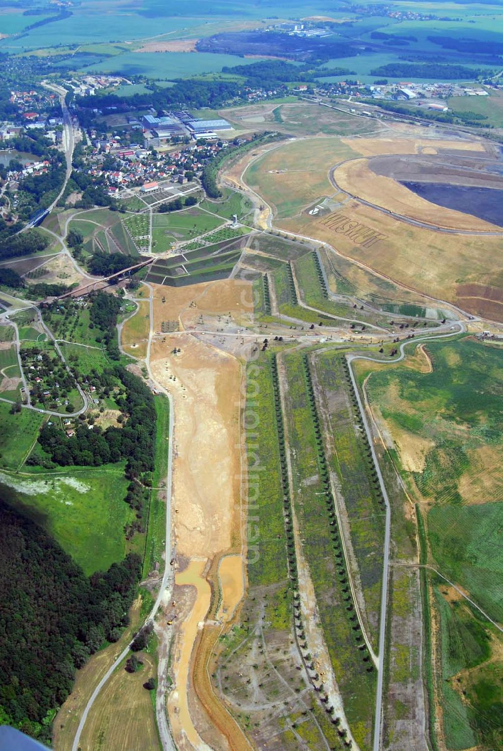 Ronneburg from above - - Auf dem Ronneburger Gelände der Bundesgartenschau 2007 (Buga), einem ehemaligen Uranabbaugebiet der Wismut, gibt es keine gefährliche radioaktive Strahlung mehr. Das ist das Ergebnis einer Expertise des Öko-Instituts Darmstadt. Die Gartenschau soll vom 27. April 2007 an mindestens 1,5 Millionen Besucher nach Gera und Ronneburg locken. Die unabhängigen Ingenieure analysierten Messwerte, die in den vergangenen Jahren von der Wismut und an deren Institutionen erhoben wurden.