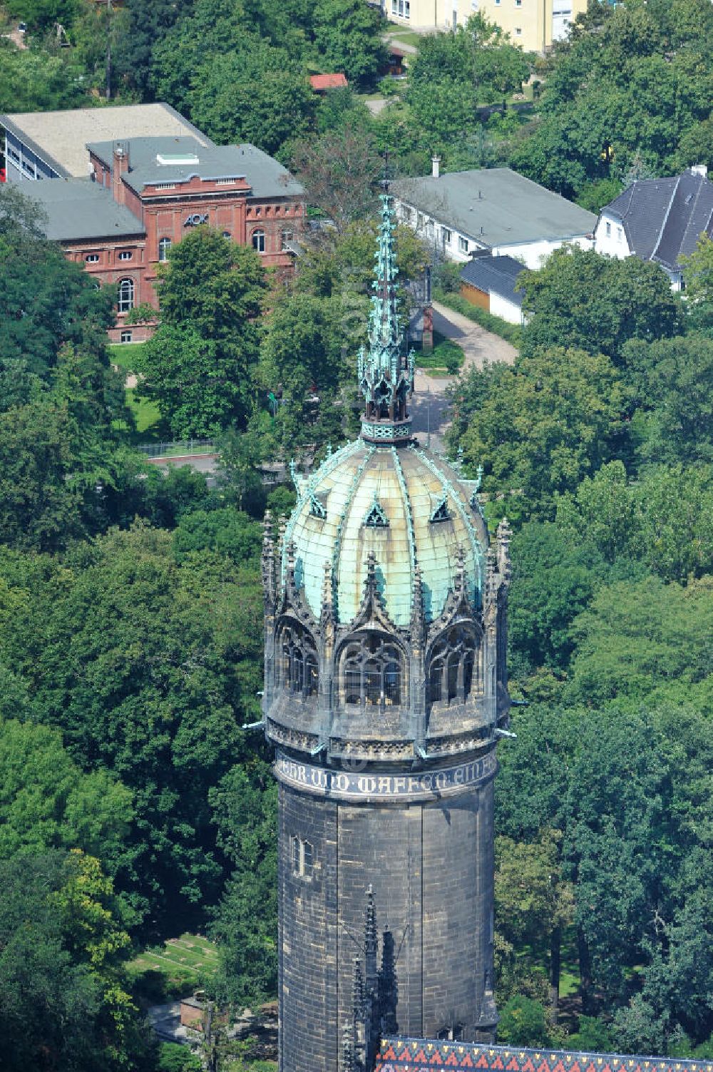 Wittenberg from the bird's eye view: Der Neugotischer Turm der Schlosskirche zu Wittenberg. Das Schloss mit seinem 88 m hohen neugotischen Kirchturm am westlichen Ende der Stadt zählt zum wichtigsten UNESCO-Weltkulturerbe. Die erste Erwähnung der Burg stammt von 1187. Berühmtheit erlangte sie, als am 31. Oktober 1517 der bis dahin nahezu unbekannte Wittenberger Augustinermönch und Theologieprofessor Martin Luther seine 95 lateinischen Disputationsthesen verbreitete. Heute befinden sich im Schloss eine Jugendherberge, das Riemer-Museum und die stadtgeschichtlichen Sammlungen. Tower of the Castle Church of Wittenberg.