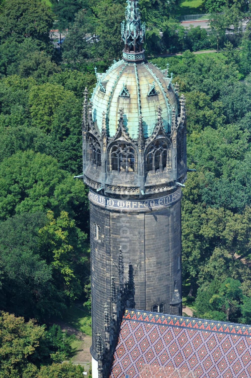 Wittenberg from above - Der Neugotischer Turm der Schlosskirche zu Wittenberg. Das Schloss mit seinem 88 m hohen neugotischen Kirchturm am westlichen Ende der Stadt zählt zum wichtigsten UNESCO-Weltkulturerbe. Die erste Erwähnung der Burg stammt von 1187. Berühmtheit erlangte sie, als am 31. Oktober 1517 der bis dahin nahezu unbekannte Wittenberger Augustinermönch und Theologieprofessor Martin Luther seine 95 lateinischen Disputationsthesen verbreitete. Heute befinden sich im Schloss eine Jugendherberge, das Riemer-Museum und die stadtgeschichtlichen Sammlungen. Tower of the Castle Church of Wittenberg.