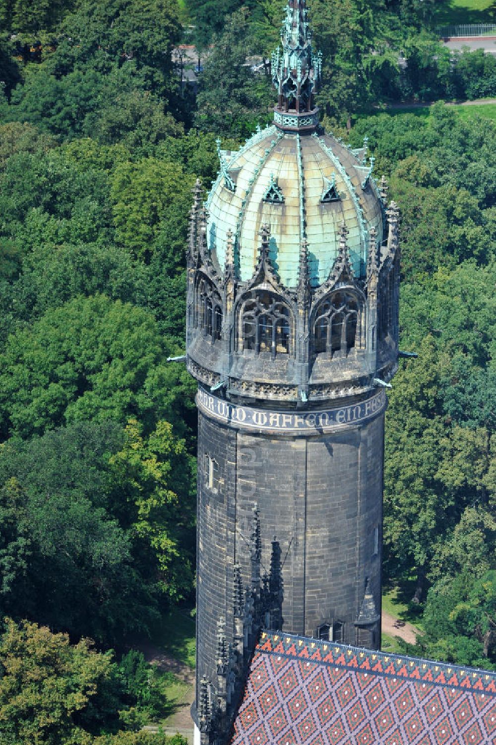 Wittenberg from the bird's eye view: Der Neugotischer Turm der Schlosskirche zu Wittenberg. Das Schloss mit seinem 88 m hohen neugotischen Kirchturm am westlichen Ende der Stadt zählt zum wichtigsten UNESCO-Weltkulturerbe. Die erste Erwähnung der Burg stammt von 1187. Berühmtheit erlangte sie, als am 31. Oktober 1517 der bis dahin nahezu unbekannte Wittenberger Augustinermönch und Theologieprofessor Martin Luther seine 95 lateinischen Disputationsthesen verbreitete. Heute befinden sich im Schloss eine Jugendherberge, das Riemer-Museum und die stadtgeschichtlichen Sammlungen. Tower of the Castle Church of Wittenberg.