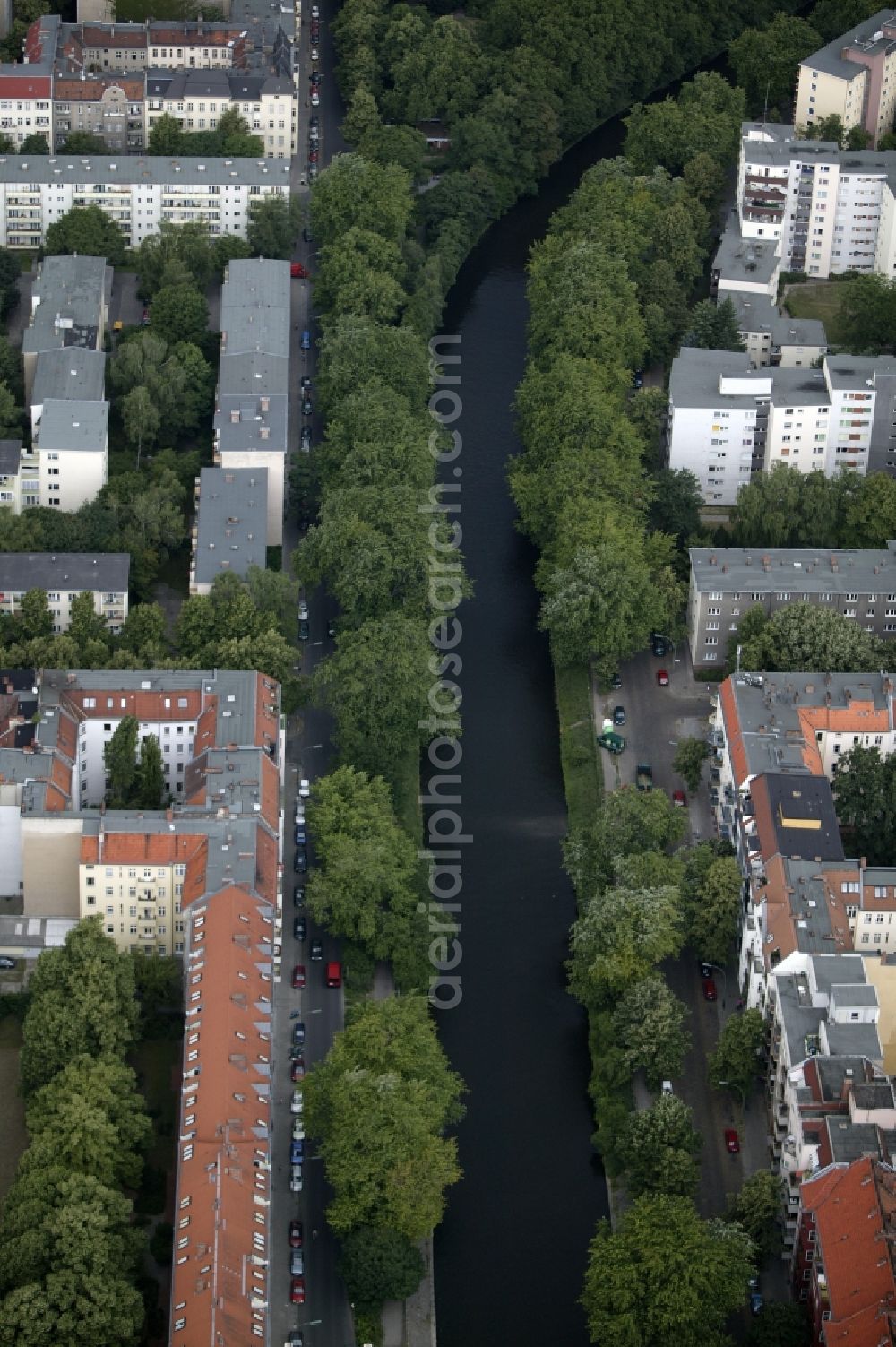 Berlin from above - Meet the Neukoelln shipping canal in Berlin in the state of Berlin, the two districts Neukoelln and Treptow together. The waterway is a green oasis in the densely built apartment buildings and commercial complexes district on the streets Kielufer and Weigandufer