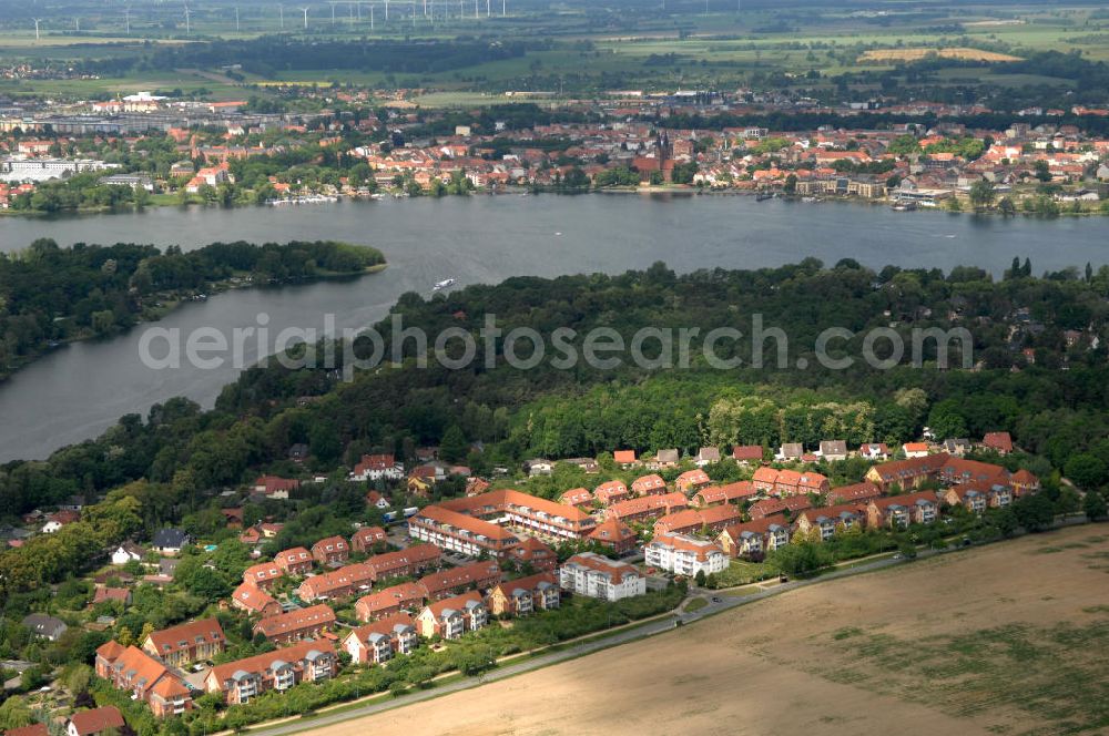 Aerial photograph Neuruppin - Blick über eine Neubau-Wohnsiedlung mit Mehrfamilienhäuser und Einfamilienhäuser auf die Wuthenower Lanke, ein Seitenarm des Ruppiner See. Am direkt gegenüber liegenden Seeufer befindet sich die Kernstadt von Neuruppin.