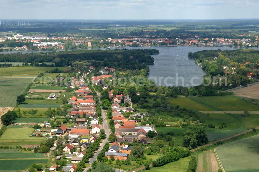 Aerial photograph Neuruppin - Blick über Wohnbauten an der Dorfstrasse im Ortsteil Wuthenow der brandenburgischen Kreisstadt Neuruppin im Landkreis Ostprignitz-Ruppin; auf die Wuthenower Lanke, ein Seitenarm des Ruppiner See. Am direkt gegenüber liegenden Seeufer befindet sich die Kernstadt von Neuruppin.