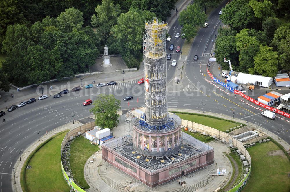 Berlin from the bird's eye view: Blick auf die wegen Baumaßnahmen verhüllte und eingerüstete Siegessäule im Berliner Tiergarten. Derzeit wird die Siegessäule umfassend renoviert, unter an derem mit einer kompletten Neuvergoldung der Viktoria. Auf der Straße des 17. Juni ist die Fanmeile zur WM 2010 zu sehen. View of the construction work at the Victory Column in Berlin's Tiergarten. Currently, the Victory Column is completely renovated, including a complete new gilding of Victoria.