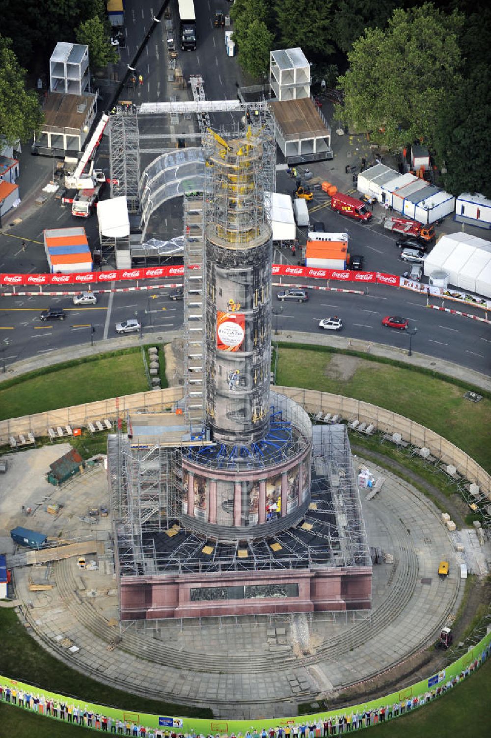 Berlin from above - Blick auf die wegen Baumaßnahmen verhüllte und eingerüstete Siegessäule im Berliner Tiergarten. Derzeit wird die Siegessäule umfassend renoviert, unter an derem mit einer kompletten Neuvergoldung der Viktoria. Auf der Straße des 17. Juni ist die Fanmeile zur WM 2010 zu sehen. View of the construction work at the Victory Column in Berlin's Tiergarten. Currently, the Victory Column is completely renovated, including a complete new gilding of Victoria.