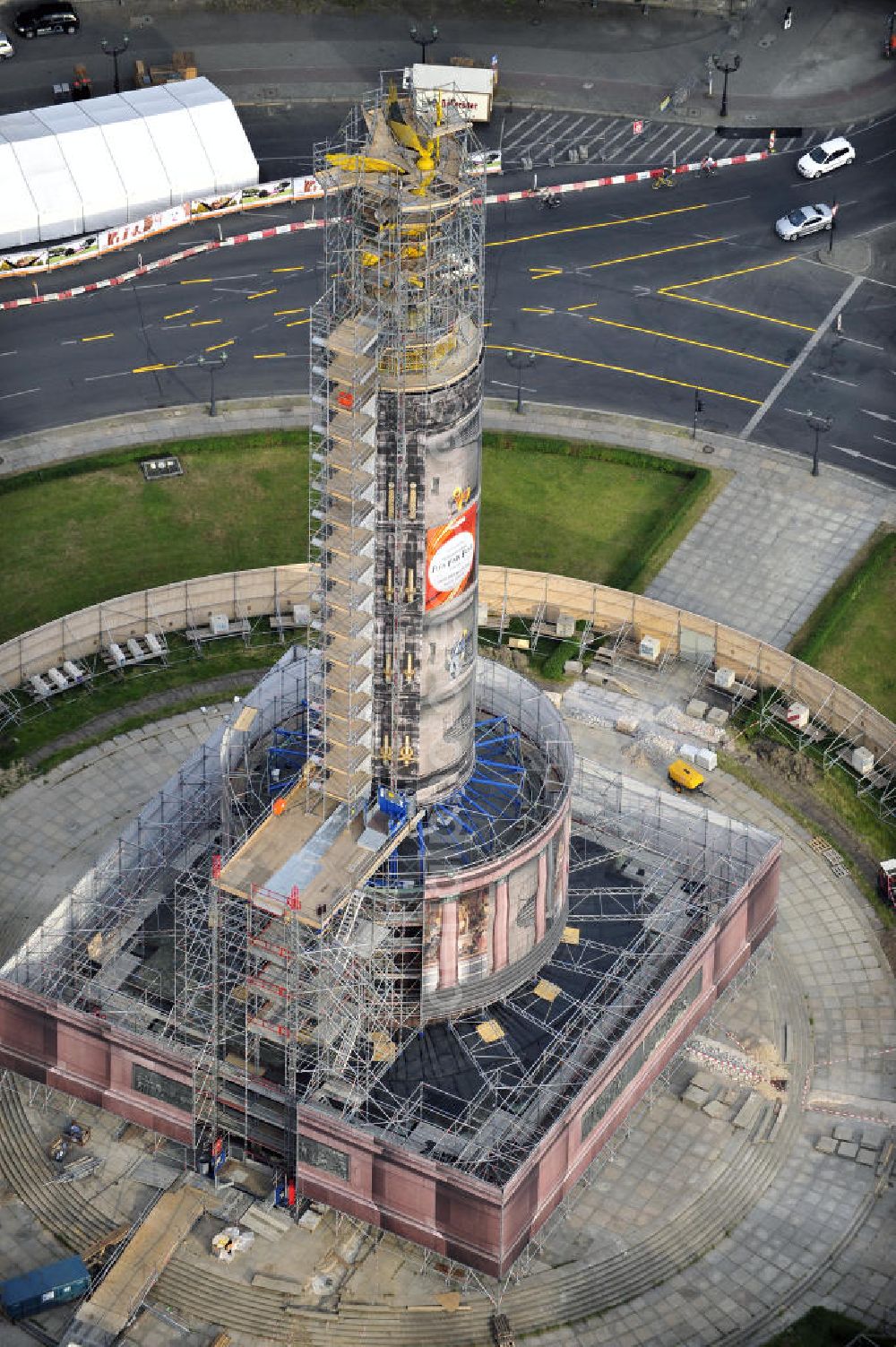 Aerial photograph Berlin - Blick auf die wegen Baumaßnahmen verhüllte und eingerüstete Siegessäule im Berliner Tiergarten. Derzeit wird die Siegessäule umfassend renoviert, unter an derem mit einer kompletten Neuvergoldung der Viktoria. Auf der Straße des 17. Juni ist die Fanmeile zur WM 2010 zu sehen. View of the construction work at the Victory Column in Berlin's Tiergarten. Currently, the Victory Column is completely renovated, including a complete new gilding of Victoria.