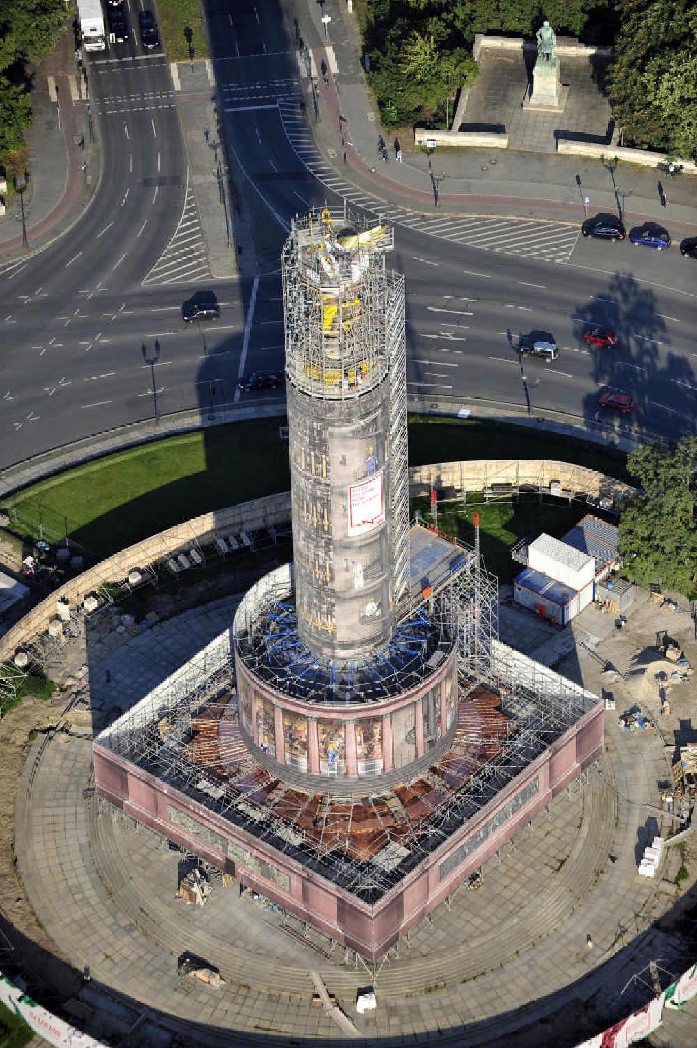 Aerial photograph Berlin - Blick auf die wegen Baumaßnahmen verhüllte und eingerüstete Siegessäule im Berliner Tiergarten. Derzeit wird die Siegessäule umfassend renoviert, unter an derem mit einer kompletten Neuvergoldung der Viktoria. Auf der Straße des 17. Juni ist die Fanmeile zur WM 2010 zu sehen. View of the construction work at the Victory Column in Berlin's Tiergarten. Currently, the Victory Column is completely renovated, including a complete new gilding of Victoria.